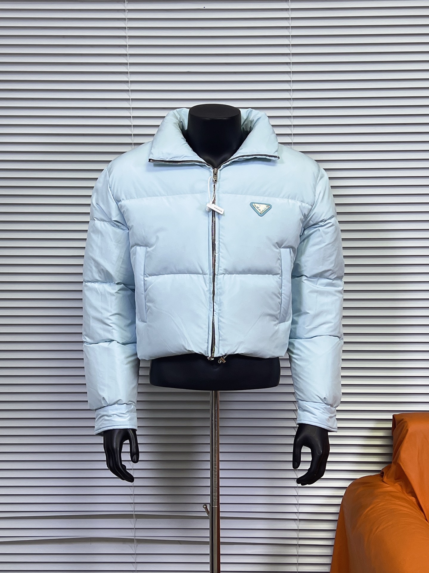 工厂直供💰280
普拉达PRADA 女士短款羽绒服🤫

描述：Prada-短款羽绒服这款羽绒外套采用Re-Nvlon再生尼龙打造，融合现代设计和新颖计的短裁版型。 

材料工艺解析： 
1、"白鸭绒绒加衬给予温暖防护，标志性的涂珐琅金属三角形徽标彰显品牌格调。 
2、创新性Re-Nvlon再生尼龙通过提纯海洋塑料回收物制成，是品牌标志性的面料。 
3、短裁版型鹅绒加衬·立领衬衫袖拉链拉合拉链式嵌线袋织物束绳下摆涂珐琅金属三角形徽标 
4、80%纯白鸭绒，市面独家使用顶级羽绒，绝不吹虚鹅绒等一系列的错误理解 
5、面料: 100% 锦纶; 里料: 100% 锦纶 ，市面最顶级没有之一，一切遵照原版定制。 
6、原代加工厂出品电镀五金，全部原厂定制，非市场各类复刻版，真正做到1:1

颜色：黑色 白色 天蓝色
尺码：36 38 40 42