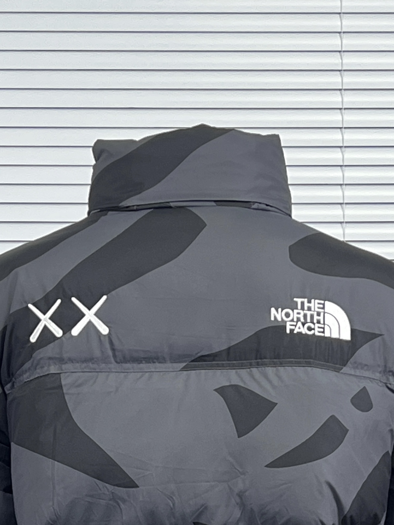 工厂放货💰280
THE NORTH FACE/北面 KAWS联名系列1996Nuptse羽绒服
联名搭配双方标志性的Logo，玩味和辨识度极高，相信潮流爱好者会非常喜爱的～
衣身满幅经典的刺绣印花涂鸦点缀，Brain Dea
实验性设计风格的注入，搭配双方标志性LOGO，玩味和辨识度极高，田岛精织工艺刺绣图案，—如既往的稳！
明星同款！男女同款！

✨拉链式可拆卸：ZIP IN自由搭配，温度随心掌控
✨ 轻质耐久面料：舒适耐磨易打理，增强穿着的耐久性，外层DWR防泼水处理科技，将水分阻截在面料表面，且这种处理会增强面料的透气性，并在加快其干燥速度的同时，能有效阻尘、阻油，保持服饰表面洁净
✨700蓬松度鹅绒填充：采用经联盟RDS认证的高品质高蓬松度鹅绒填充，保暖性能更出色，轻便不厚重，且压缩后的蓬松度恢复性好
✨功能性风帽：隐藏收纳，切换自如帽口带可调节绳扣，可为户外活动提供舒适防护，无需风帽时，也可将风帽折叠隐藏收纳塞入领内，轻松便捷
✨半弹力可调节袖口：袖口带魔术贴粘扣设计，灵活调节，舒适自如
✨全新百灵达绣花机定制万针电绣，刺绣不连线，饱满且立体！

面料到辅料各方面全部都是原厂配件
原厂TNF logo四合扣
全新版本的防伪水洗镭射标
yk定制拉链，字迹清晰
区别别家的棉服，垃圾刺绣版本，纯羽绒服！！
每一个细节苛求完美 辅料 版型 充绒量 分分钟过专柜毫无压力，每一件成衣 经过安检公司质检，与每做一批成衣换一批崭新针杆，内里两层内胆 面料特殊工艺定制

颜色：白迷彩，黑迷彩，绿迷彩，灰迷彩
尺码：XS-XXL