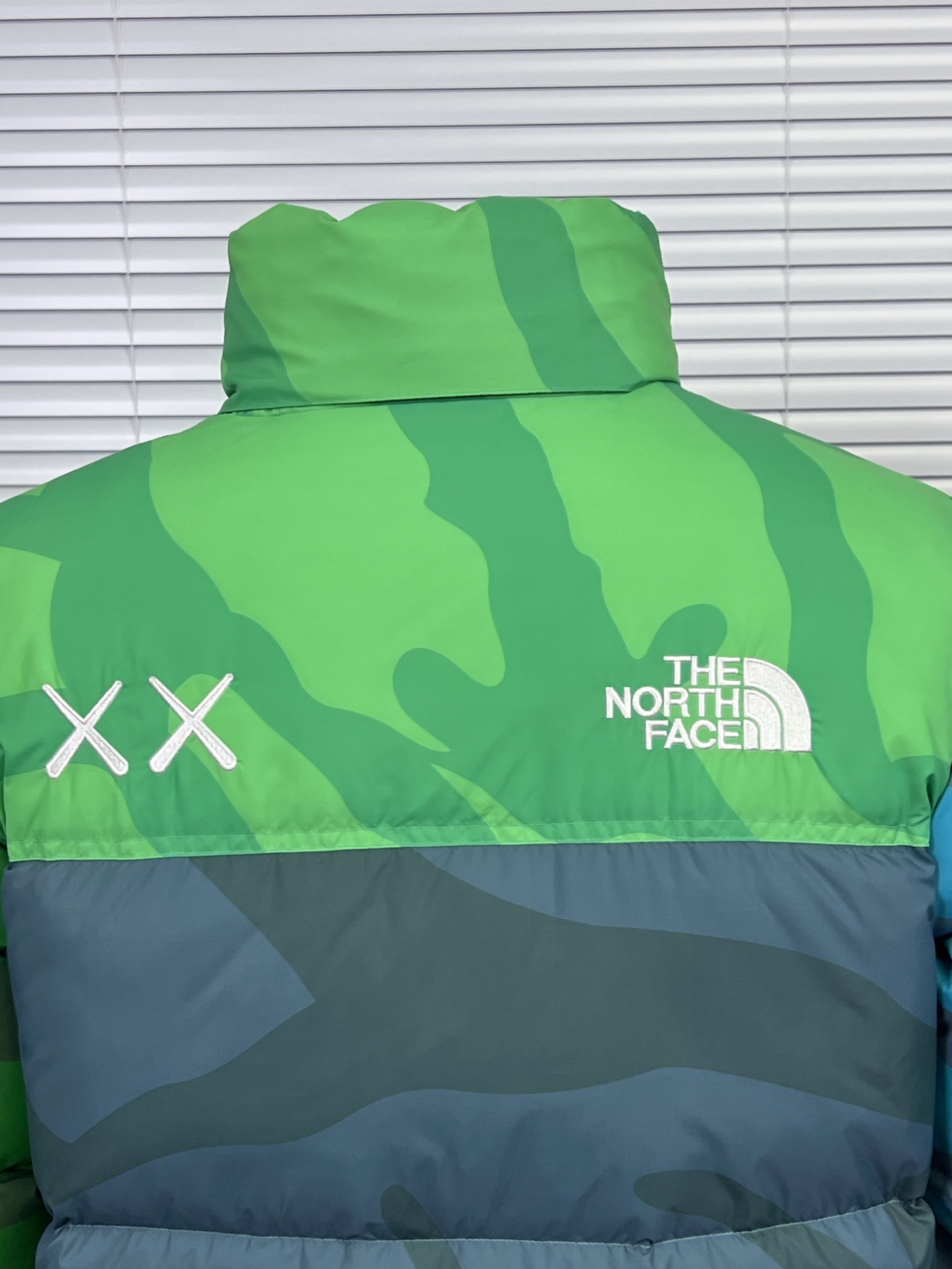 工厂放货💰280
THE NORTH FACE/北面 KAWS联名系列1996Nuptse羽绒服
联名搭配双方标志性的Logo，玩味和辨识度极高，相信潮流爱好者会非常喜爱的～
衣身满幅经典的刺绣印花涂鸦点缀，Brain Dea
实验性设计风格的注入，搭配双方标志性LOGO，玩味和辨识度极高，田岛精织工艺刺绣图案，—如既往的稳！
明星同款！男女同款！

✨拉链式可拆卸：ZIP IN自由搭配，温度随心掌控
✨ 轻质耐久面料：舒适耐磨易打理，增强穿着的耐久性，外层DWR防泼水处理科技，将水分阻截在面料表面，且这种处理会增强面料的透气性，并在加快其干燥速度的同时，能有效阻尘、阻油，保持服饰表面洁净
✨700蓬松度鹅绒填充：采用经联盟RDS认证的高品质高蓬松度鹅绒填充，保暖性能更出色，轻便不厚重，且压缩后的蓬松度恢复性好
✨功能性风帽：隐藏收纳，切换自如帽口带可调节绳扣，可为户外活动提供舒适防护，无需风帽时，也可将风帽折叠隐藏收纳塞入领内，轻松便捷
✨半弹力可调节袖口：袖口带魔术贴粘扣设计，灵活调节，舒适自如
✨全新百灵达绣花机定制万针电绣，刺绣不连线，饱满且立体！

面料到辅料各方面全部都是原厂配件
原厂TNF logo四合扣
全新版本的防伪水洗镭射标
yk定制拉链，字迹清晰
区别别家的棉服，垃圾刺绣版本，纯羽绒服！！
每一个细节苛求完美 辅料 版型 充绒量 分分钟过专柜毫无压力，每一件成衣 经过安检公司质检，与每做一批成衣换一批崭新针杆，内里两层内胆 面料特殊工艺定制

颜色：白迷彩，黑迷彩，绿迷彩，灰迷彩
尺码：XS-XXL