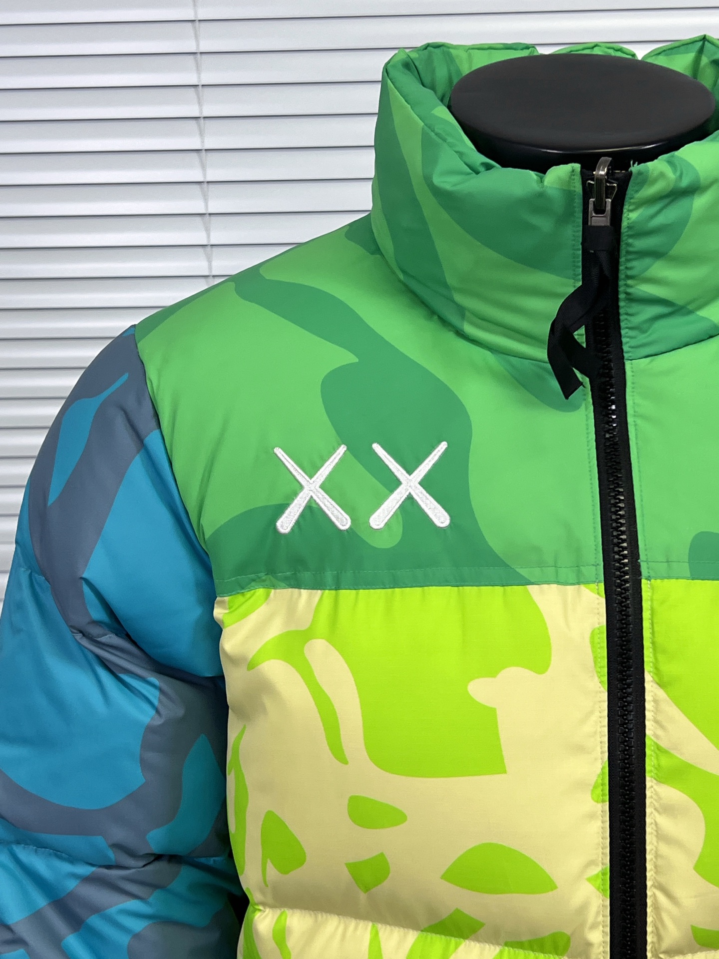 工厂放货💰280
THE NORTH FACE/北面 KAWS联名系列1996Nuptse羽绒服
联名搭配双方标志性的Logo，玩味和辨识度极高，相信潮流爱好者会非常喜爱的～
衣身满幅经典的刺绣印花涂鸦点缀，Brain Dea
实验性设计风格的注入，搭配双方标志性LOGO，玩味和辨识度极高，田岛精织工艺刺绣图案，—如既往的稳！
明星同款！男女同款！

✨拉链式可拆卸：ZIP IN自由搭配，温度随心掌控
✨ 轻质耐久面料：舒适耐磨易打理，增强穿着的耐久性，外层DWR防泼水处理科技，将水分阻截在面料表面，且这种处理会增强面料的透气性，并在加快其干燥速度的同时，能有效阻尘、阻油，保持服饰表面洁净
✨700蓬松度鹅绒填充：采用经联盟RDS认证的高品质高蓬松度鹅绒填充，保暖性能更出色，轻便不厚重，且压缩后的蓬松度恢复性好
✨功能性风帽：隐藏收纳，切换自如帽口带可调节绳扣，可为户外活动提供舒适防护，无需风帽时，也可将风帽折叠隐藏收纳塞入领内，轻松便捷
✨半弹力可调节袖口：袖口带魔术贴粘扣设计，灵活调节，舒适自如
✨全新百灵达绣花机定制万针电绣，刺绣不连线，饱满且立体！

面料到辅料各方面全部都是原厂配件
原厂TNF logo四合扣
全新版本的防伪水洗镭射标
yk定制拉链，字迹清晰
区别别家的棉服，垃圾刺绣版本，纯羽绒服！！
每一个细节苛求完美 辅料 版型 充绒量 分分钟过专柜毫无压力，每一件成衣 经过安检公司质检，与每做一批成衣换一批崭新针杆，内里两层内胆 面料特殊工艺定制

颜色：白迷彩，黑迷彩，绿迷彩，灰迷彩
尺码：XS-XXL