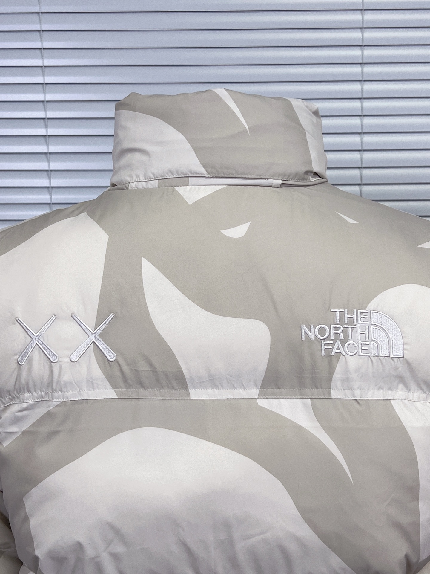 工厂放货💰280
THE NORTH FACE/北面 KAWS联名系列1996Nuptse羽绒服
联名搭配双方标志性的Logo，玩味和辨识度极高，相信潮流爱好者会非常喜爱的～
衣身满幅经典的刺绣印花涂鸦点缀，Brain Dea
实验性设计风格的注入，搭配双方标志性LOGO，玩味和辨识度极高，田岛精织工艺刺绣图案，—如既往的稳！
明星同款！男女同款！

✨拉链式可拆卸：ZIP IN自由搭配，温度随心掌控
✨ 轻质耐久面料：舒适耐磨易打理，增强穿着的耐久性，外层DWR防泼水处理科技，将水分阻截在面料表面，且这种处理会增强面料的透气性，并在加快其干燥速度的同时，能有效阻尘、阻油，保持服饰表面洁净
✨700蓬松度鹅绒填充：采用经联盟RDS认证的高品质高蓬松度鹅绒填充，保暖性能更出色，轻便不厚重，且压缩后的蓬松度恢复性好
✨功能性风帽：隐藏收纳，切换自如帽口带可调节绳扣，可为户外活动提供舒适防护，无需风帽时，也可将风帽折叠隐藏收纳塞入领内，轻松便捷
✨半弹力可调节袖口：袖口带魔术贴粘扣设计，灵活调节，舒适自如
✨全新百灵达绣花机定制万针电绣，刺绣不连线，饱满且立体！

面料到辅料各方面全部都是原厂配件
原厂TNF logo四合扣
全新版本的防伪水洗镭射标
yk定制拉链，字迹清晰
区别别家的棉服，垃圾刺绣版本，纯羽绒服！！
每一个细节苛求完美 辅料 版型 充绒量 分分钟过专柜毫无压力，每一件成衣 经过安检公司质检，与每做一批成衣换一批崭新针杆，内里两层内胆 面料特殊工艺定制

颜色：白迷彩，黑迷彩，绿迷彩，灰迷彩
尺码：XS-XXL