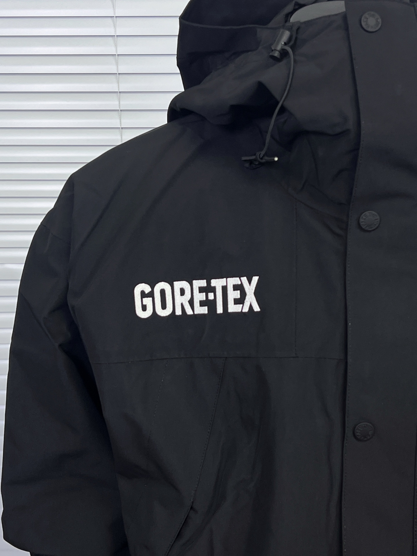 工厂放货💰240
The North Face/北面  1990 GTX系列连帽冲锋衣
1、面料：采用戈尔公司2L双层Gore-tex聚酯纤维面料，面料表层做超高强度防水，内层覆膜，所以到达三层防水的效果，使成衣具有防水防污透气的出色户外效果。独家制作整衣缝线处热封条高温压胶！
2、内里：原厂塔夫绸和拉绒经编衬里，提高贴合度，保暖防寒。区别市面低端版本。！
3、刺绣：进口田岛刺绣机还原ZP。田岛刺绣工整立体，且每处刺绣后都有防水弧形胶片！
 4、辅料：全衣原厂YKK拉链，可承受10万次拉力磨损，原厂魔术贴。开模定制五金配件，字体清晰立体 ，6颗纽扣方向全部一致！ 

继3年后北面与歌尔的再一次携手共进，联手打造UE系列！我们7月份开售日从美国购回正品，历史近三个月，克服多重困难，最终完美复刻出！整衣独家采用热封压胶技术！每一处拼接都由高温压胶条粘合，与正品保持一致！不是市面随便扯块布就是干的低端货。还原ZP 3合1完美搭配那是必须的。面料内里均采购ZP原厂进口双层Gore-tex面料、塔夫绸和拉绒经编衬里使衣服拥有ZP一样功能。整衣五金件使用zp开模定制，非市面错版，衣面6颗纽扣、四合扣、魔术贴全部重新开模！给你最细致的还原！

颜色:黑色，白色，迷彩
尺码：S-XXL