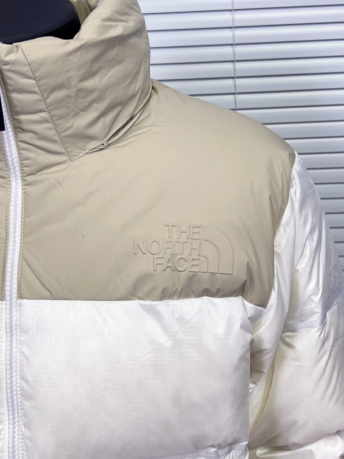 工厂 THE NORTH FACE/北面 23SS 96S日系无缝压胶羽绒服 1992 年为探险而开发的 Nuptse 夹克,作为1990 年代代表 THE NORTH FACE 的传统款式,升级为GORET-TEX INFINIUM,具有出色的防风和透湿性能.外层材料由 30 旦尼龙制成,重量轻但坚硬.无缝压胶可避免风从针孔钻入增加保温性.袖口采用粘性罗纹和压花徽标的简单饰面营造出技术形象. ❶logo:双面胸前有特俗材料由机器压制而成凹凸有形的logo 区别于是普通大众款的印花绣花工艺辨识度高 有质感 不变色不掉色. ❷工艺:96S采用科技纳米防静电防风防泼水高密度户外面料无缝压胶分仓式充绒 三层锁绒工艺防跑绒. ❸填充:百分之百90%白鸭绒填充量280克,绒手感摸起来蓬松柔软. ❹五金:拉链采用AiryString,重量轻且不损害面料原有的弹性, 追求轻盈开合. 颜色:双拼白,黑色 棕色