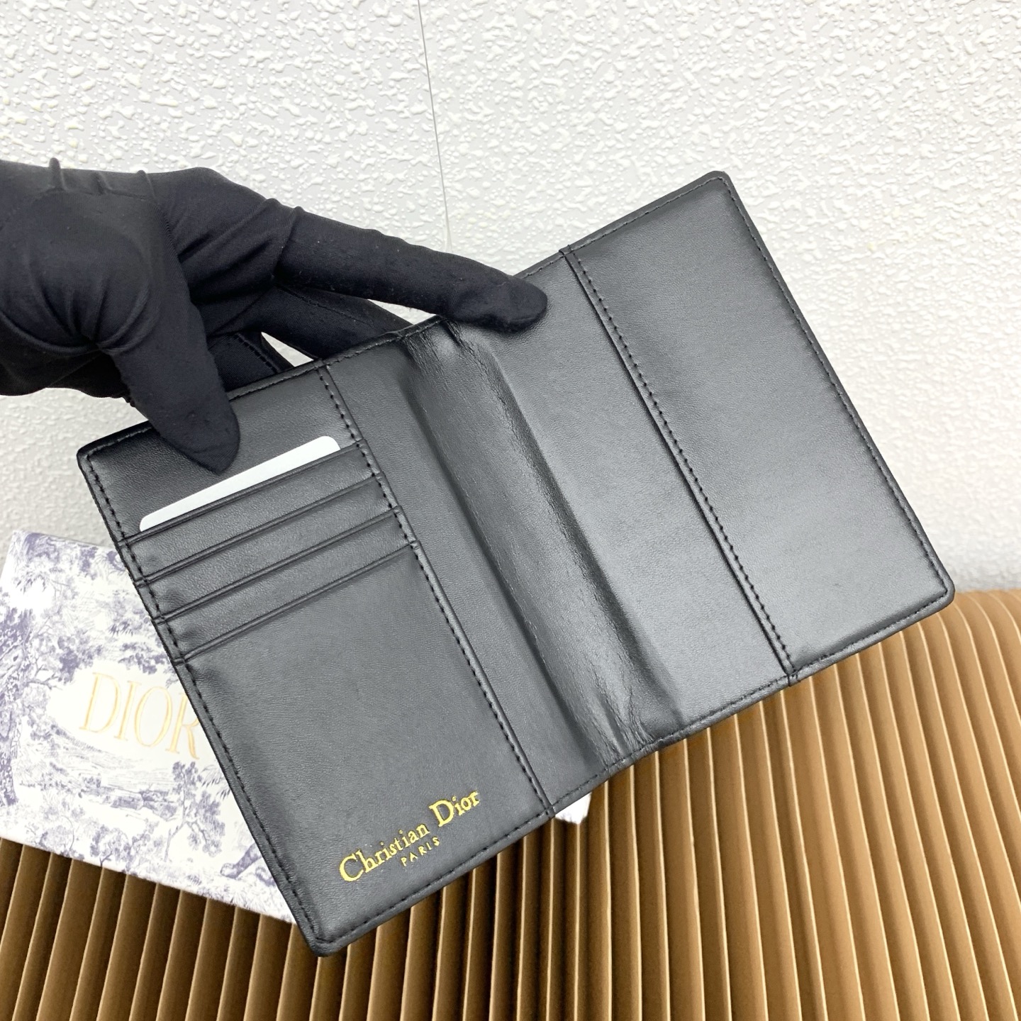 这款护照套是实用典雅的配饰。采用米色和黑色 Dior Oblique 缇花制作，正面缀以 Dior 标志