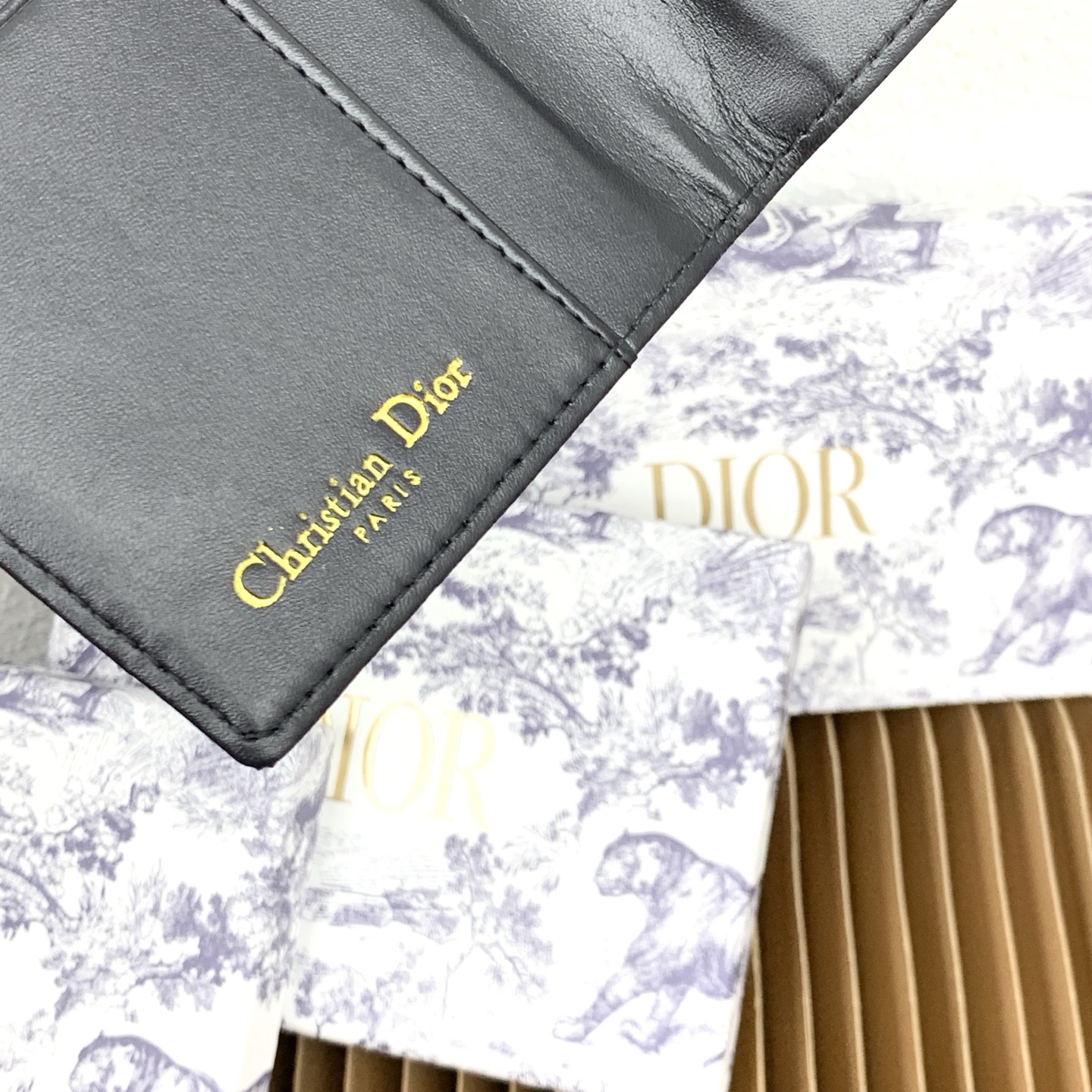 这款护照套是实用典雅的配饰。采用米色和黑色 Dior Oblique 缇花制作，正面缀以 Dior 标志