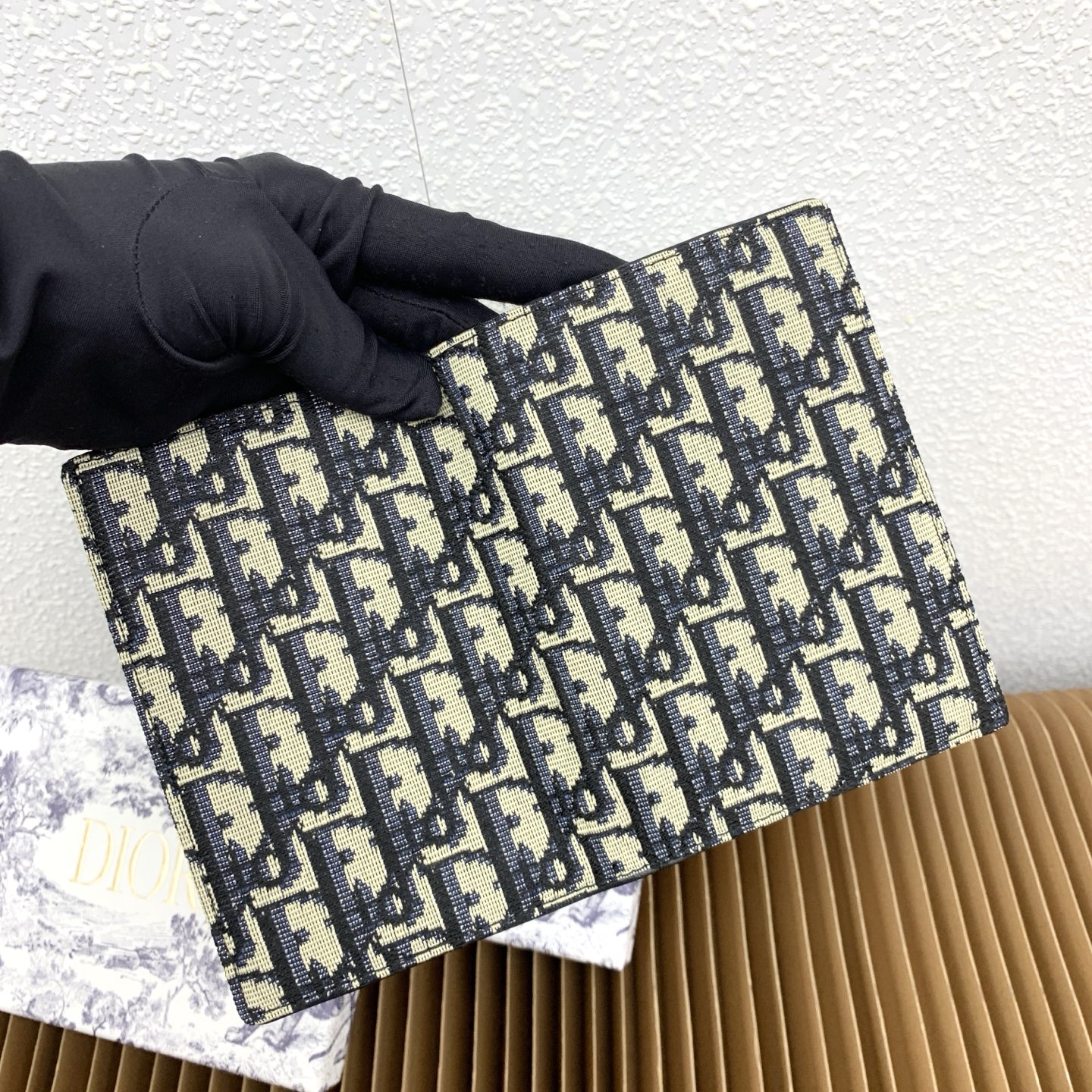 这款护照套是实用典雅的配饰。采用米色和黑色 Dior Oblique 缇花制作，正面缀以 Dior 标志