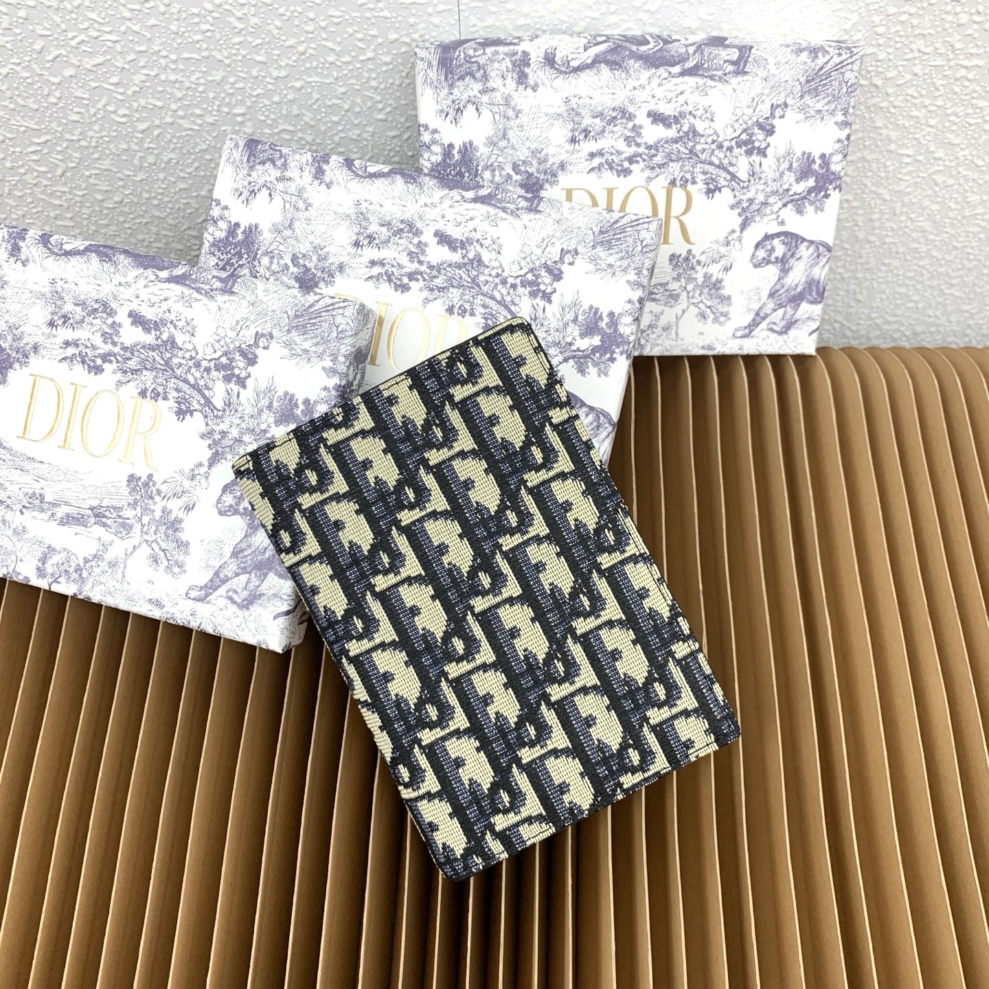 这款护照套是实用典雅的配饰。采用米色和黑色 Dior Oblique 缇花制作，正面缀以 Dior 标志