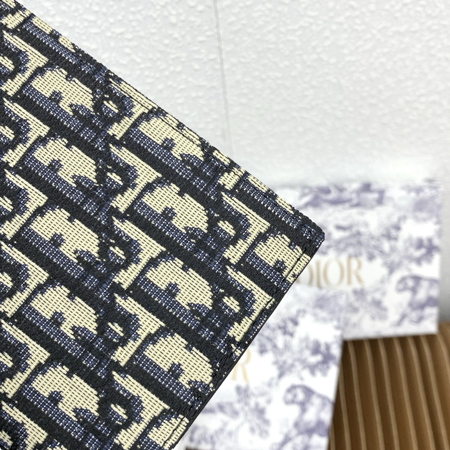 这款护照套是实用典雅的配饰。采用米色和黑色 Dior Oblique 缇花制作，正面缀以 Dior 标志