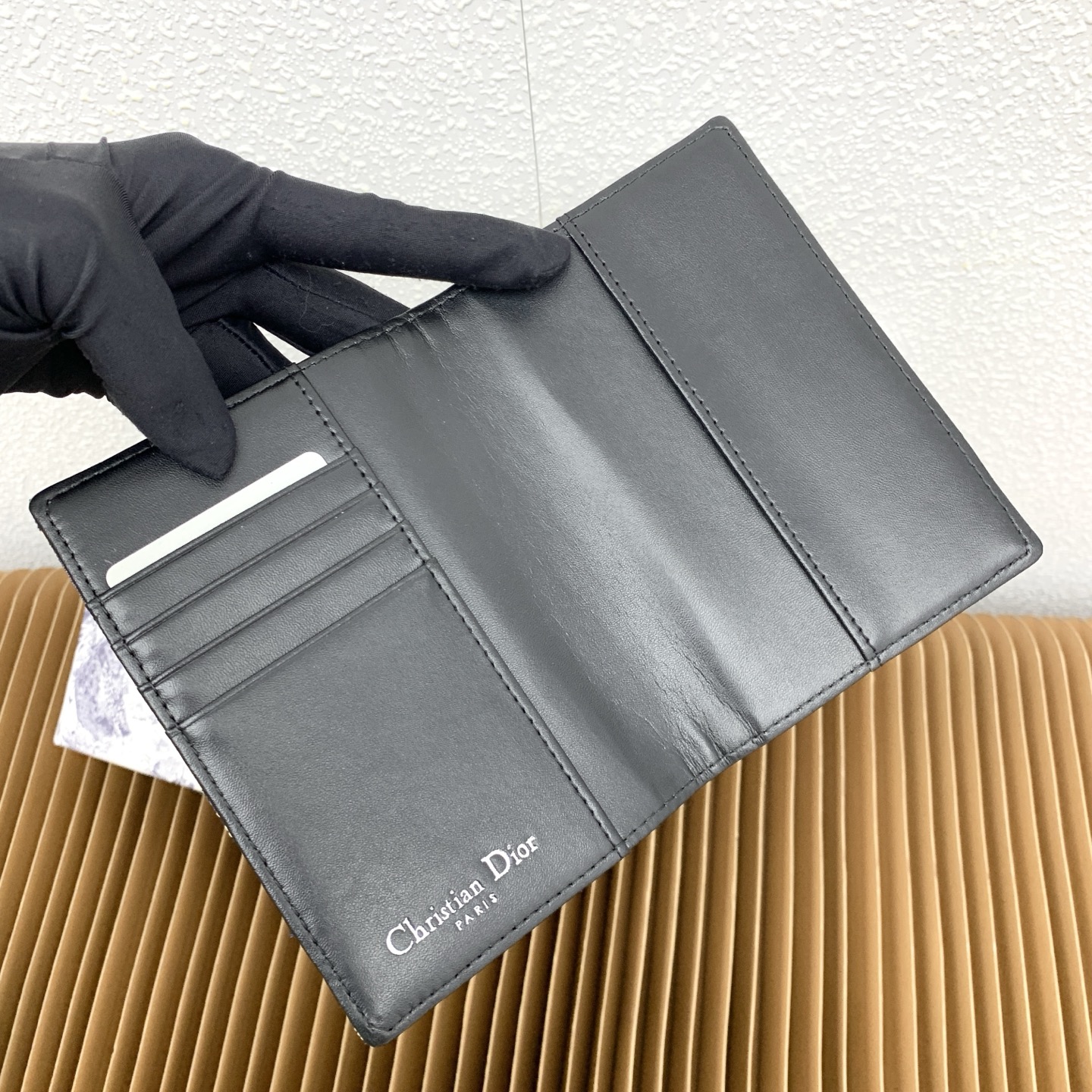 这款护照套是实用典雅的配饰。采用米色和黑色 Dior Oblique 缇花制作，正面缀以 Dior 标志