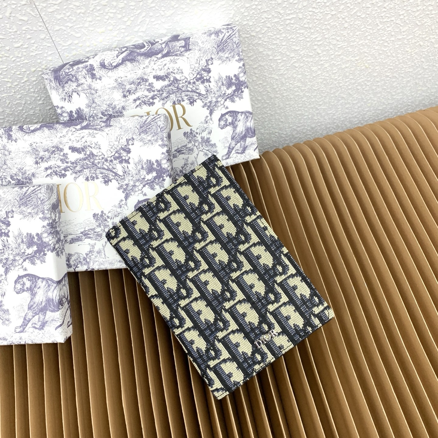 这款护照套是实用典雅的配饰。采用米色和黑色 Dior Oblique 缇花制作，正面缀以 Dior 标志