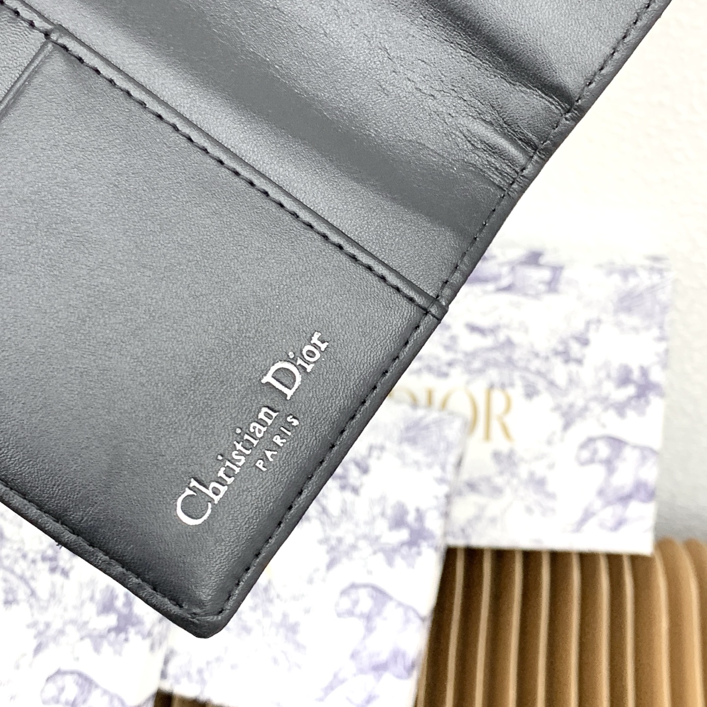 这款护照套是实用典雅的配饰。采用米色和黑色 Dior Oblique 缇花制作，正面缀以 Dior 标志