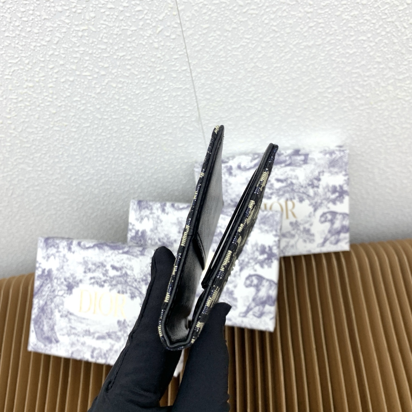 这款护照套是实用典雅的配饰。采用米色和黑色 Dior Oblique 缇花制作，正面缀以 Dior 标志