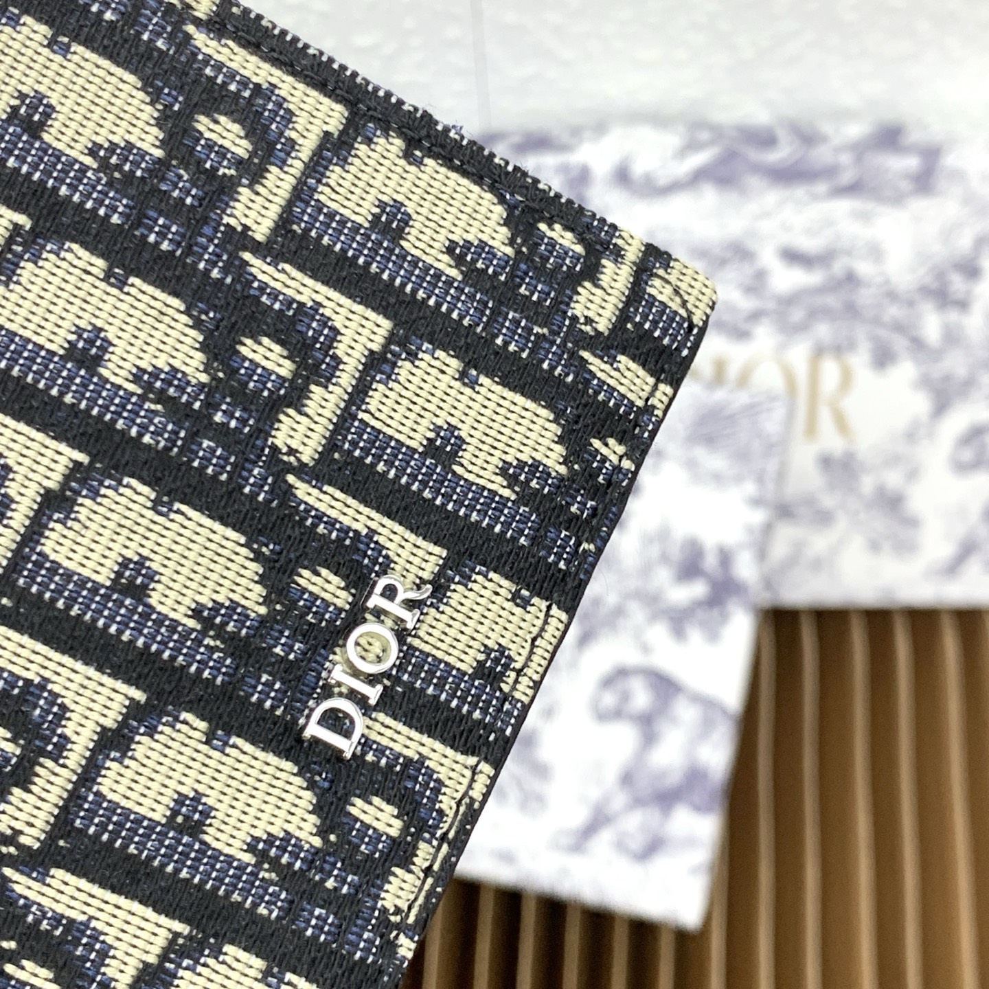 这款护照套是实用典雅的配饰。采用米色和黑色 Dior Oblique 缇花制作，正面缀以 Dior 标志