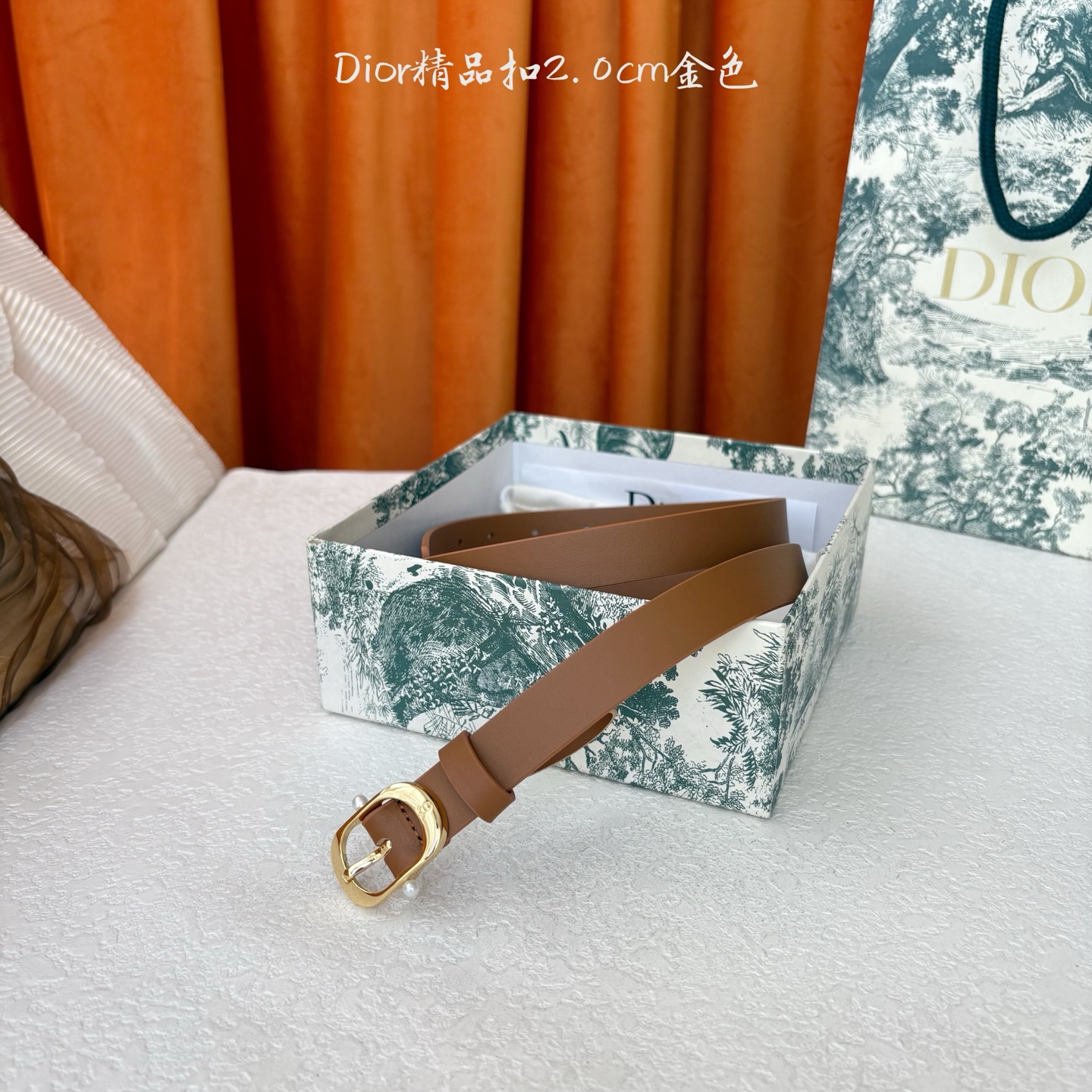 Dior新款腰带采用光滑牛皮材质精心制作，搭配富有光泽的金色饰面金属腰带扣，彰显优雅线条，并镌刻以CD标