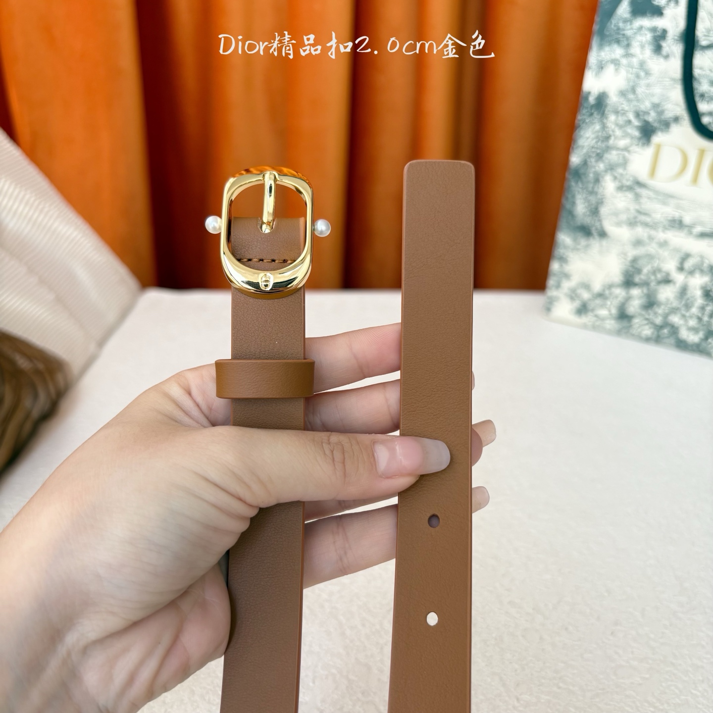 Dior新款腰带采用光滑牛皮材质精心制作，搭配富有光泽的金色饰面金属腰带扣，彰显优雅线条，并镌刻以CD标
