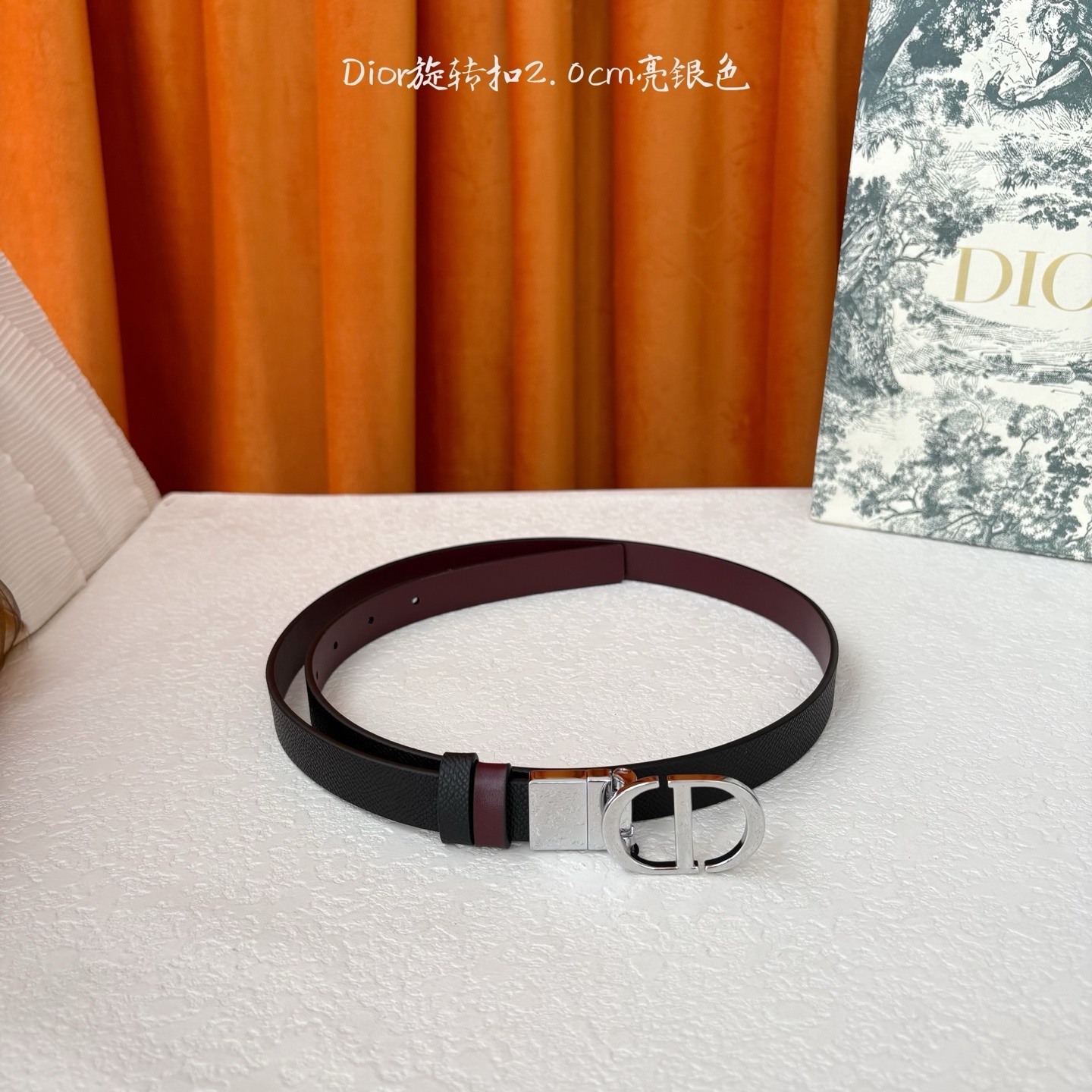 Dior新款腰带一面为黑色颗粒小牛皮,另一面为酒红色光滑小牛皮,缀以经典的亮面金色饰面金属CD扣环。此款