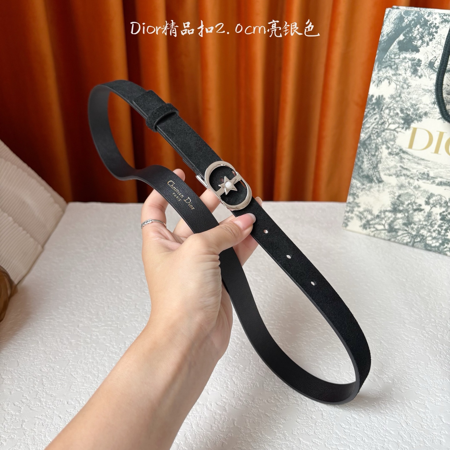Dior的马鞍腰带已成为品牌的标志性款式，是每个衣橱的必备品。这款绒面小牛皮腰带重新演绎了这一经典款式，