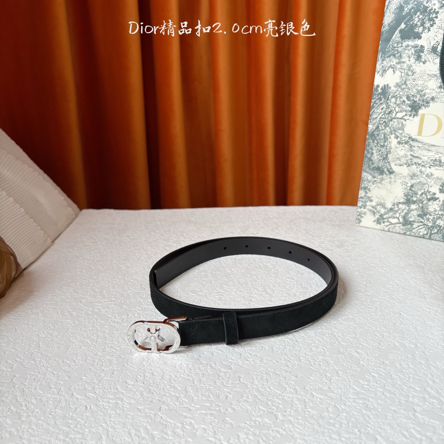 Dior的马鞍腰带已成为品牌的标志性款式，是每个衣橱的必备品。这款绒面小牛皮腰带重新演绎了这一经典款式，