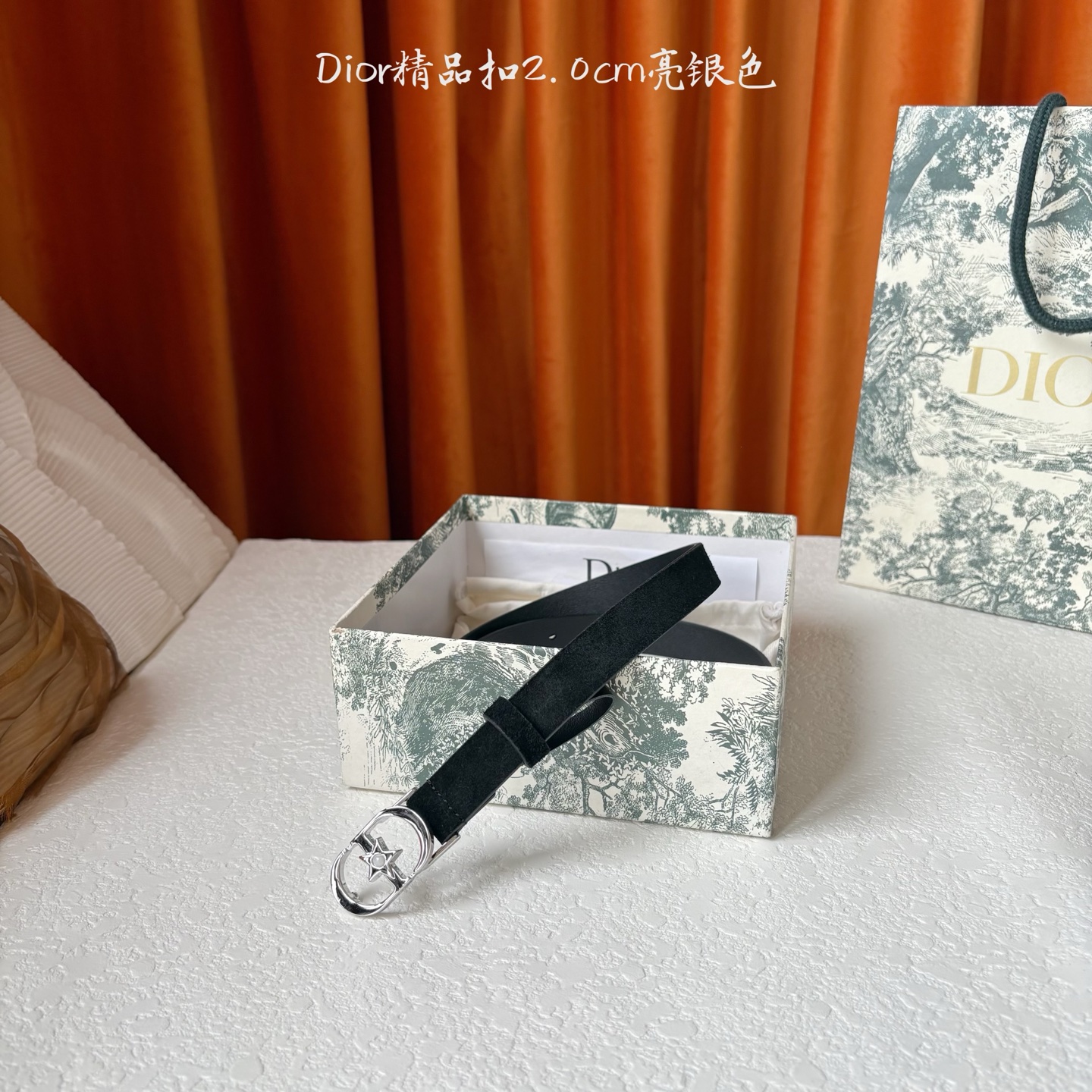 Dior的马鞍腰带已成为品牌的标志性款式，是每个衣橱的必备品。这款绒面小牛皮腰带重新演绎了这一经典款式，
