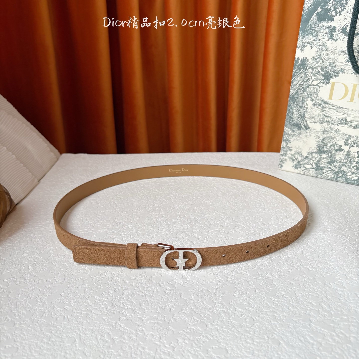 Dior的马鞍腰带已成为品牌的标志性款式，是每个衣橱的必备品。这款绒面小牛皮腰带重新演绎了这一经典款式，