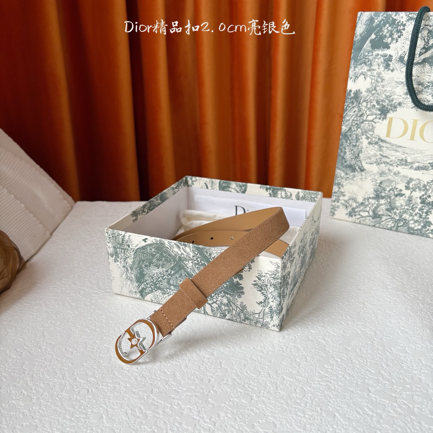Dior的马鞍腰带已成为品牌的标志性款式，是每个衣橱的必备品。这款绒面小牛皮腰带重新演绎了这一经典款式，