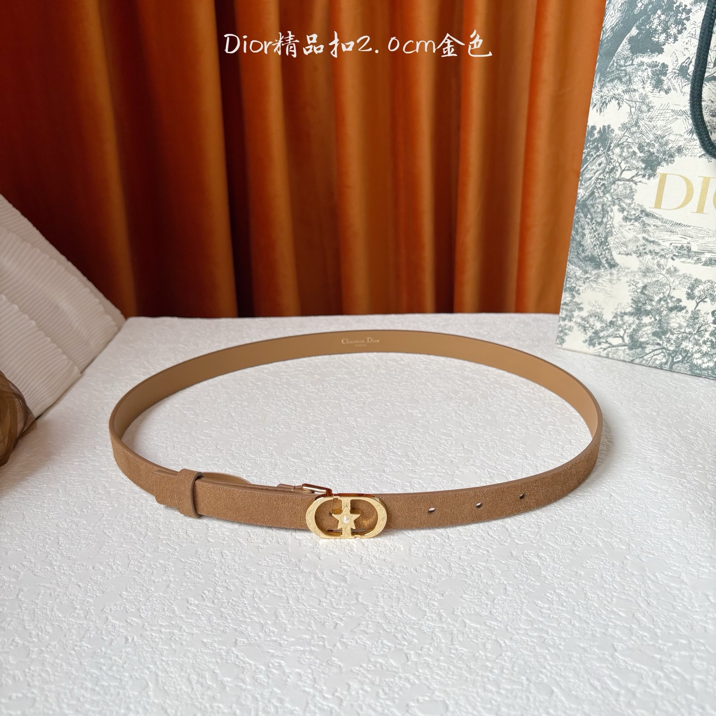 Dior的马鞍腰带已成为品牌的标志性款式，是每个衣橱的必备品。这款绒面小牛皮腰带重新演绎了这一经典款式，