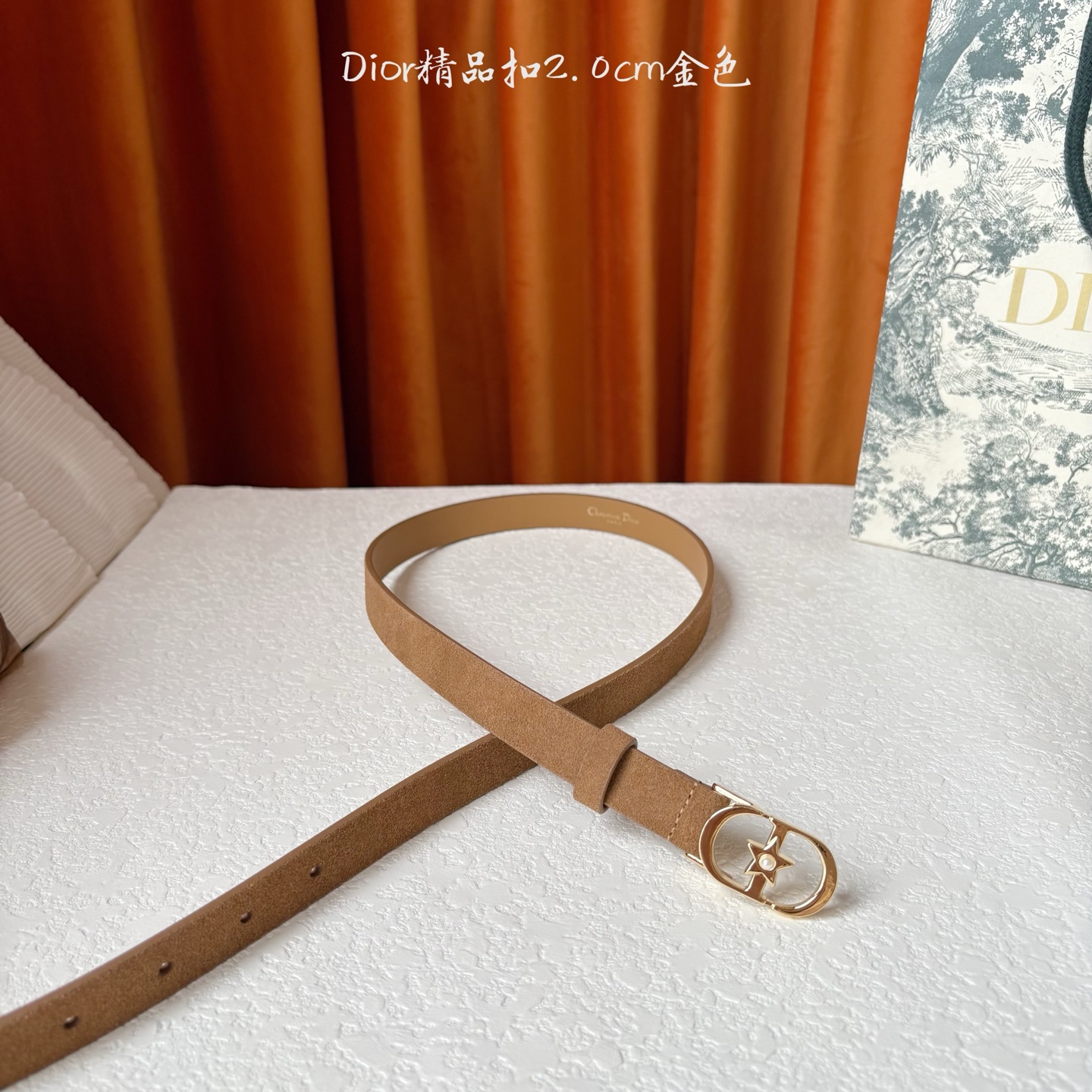 Dior的马鞍腰带已成为品牌的标志性款式，是每个衣橱的必备品。这款绒面小牛皮腰带重新演绎了这一经典款式，