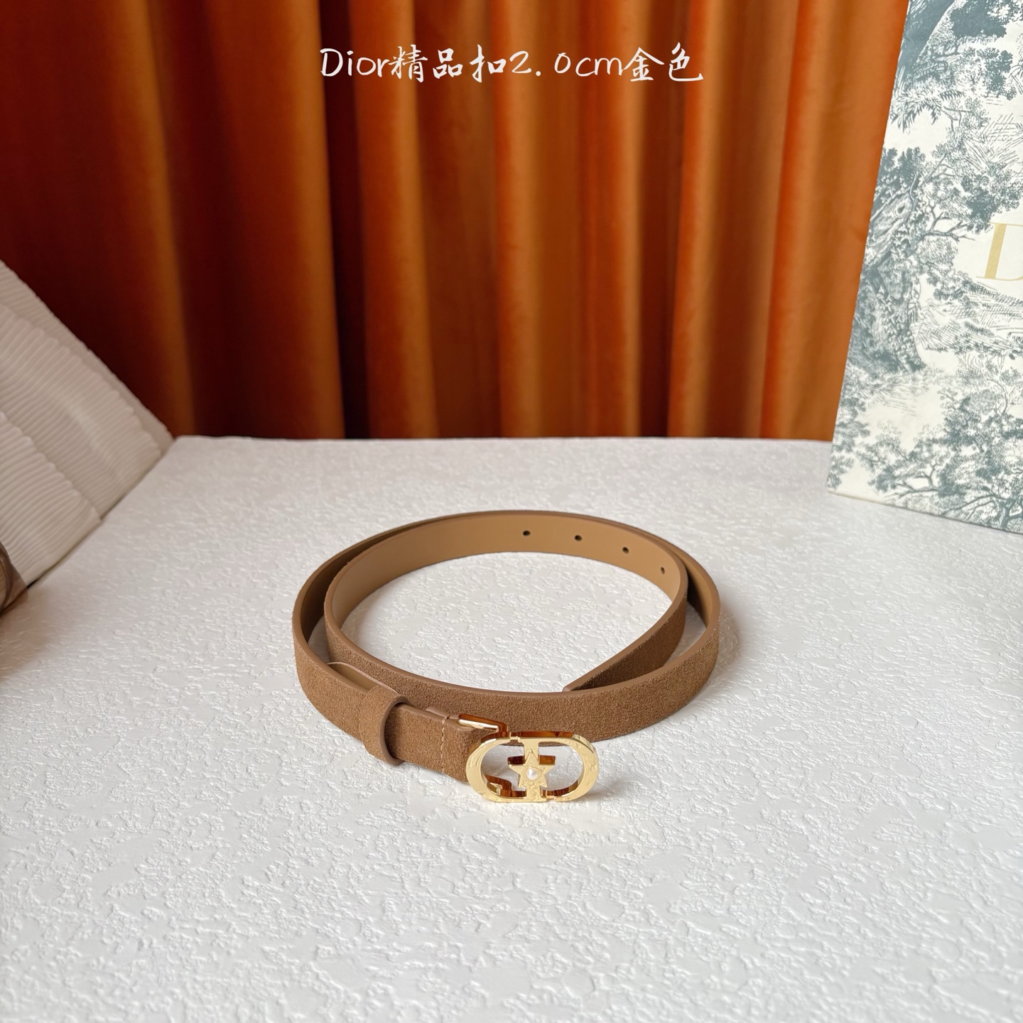 Dior的马鞍腰带已成为品牌的标志性款式，是每个衣橱的必备品。这款绒面小牛皮腰带重新演绎了这一经典款式，