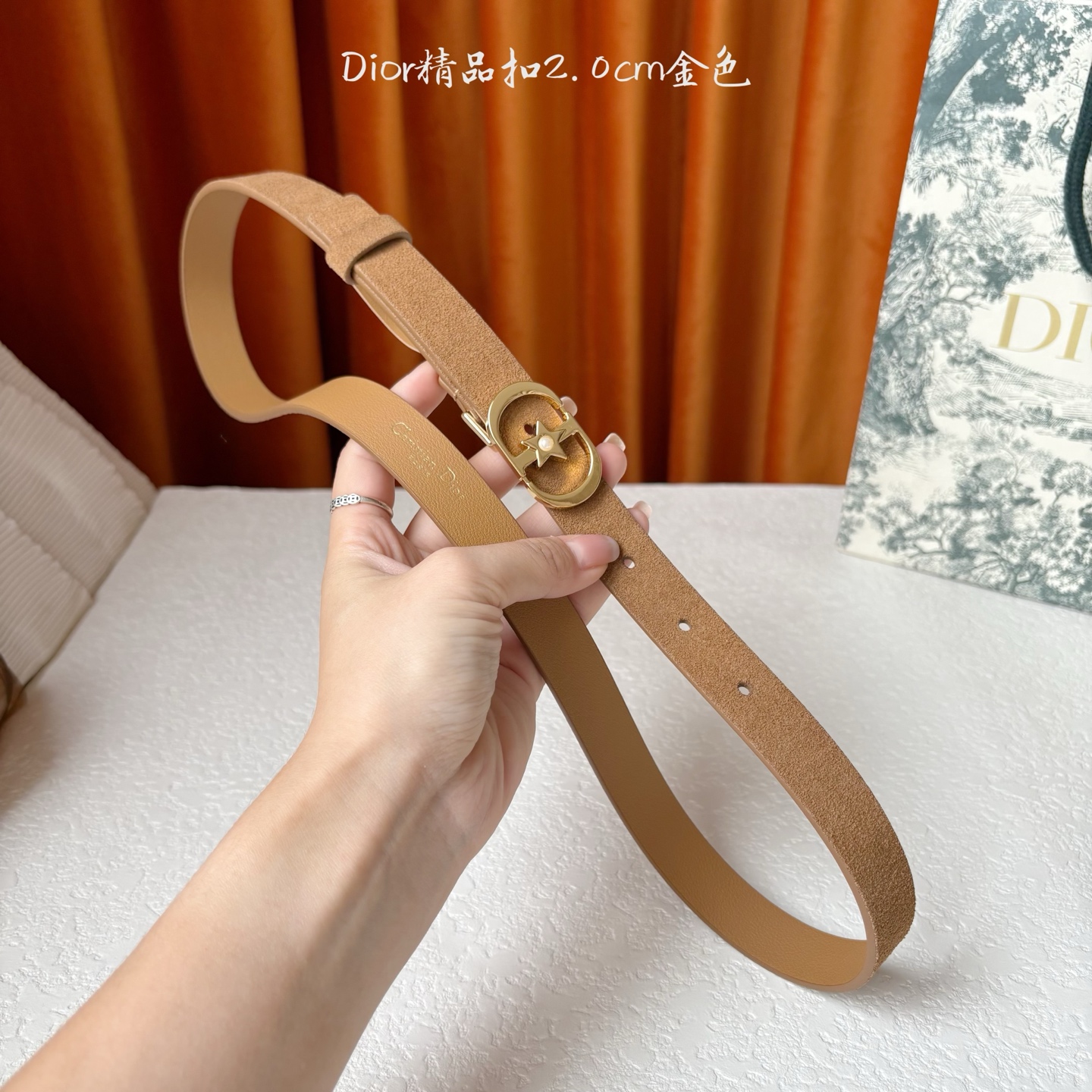 Dior的马鞍腰带已成为品牌的标志性款式，是每个衣橱的必备品。这款绒面小牛皮腰带重新演绎了这一经典款式，
