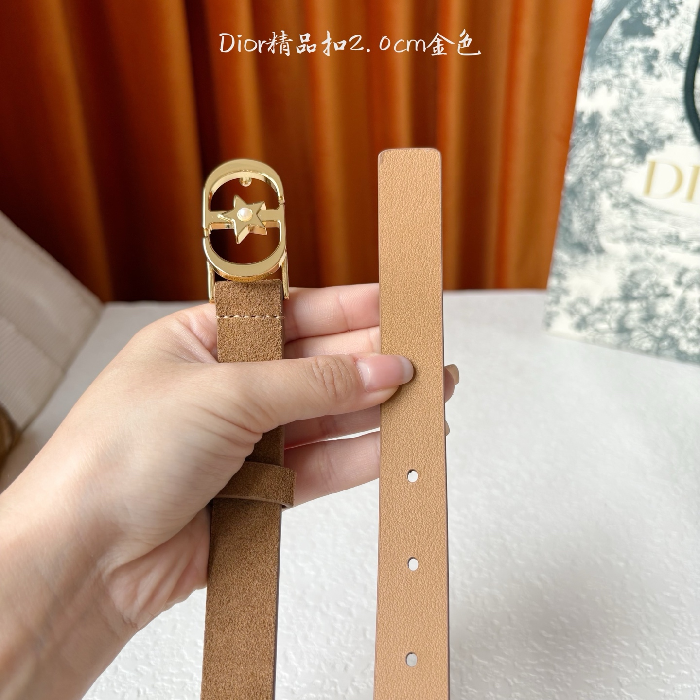 Dior的马鞍腰带已成为品牌的标志性款式，是每个衣橱的必备品。这款绒面小牛皮腰带重新演绎了这一经典款式，