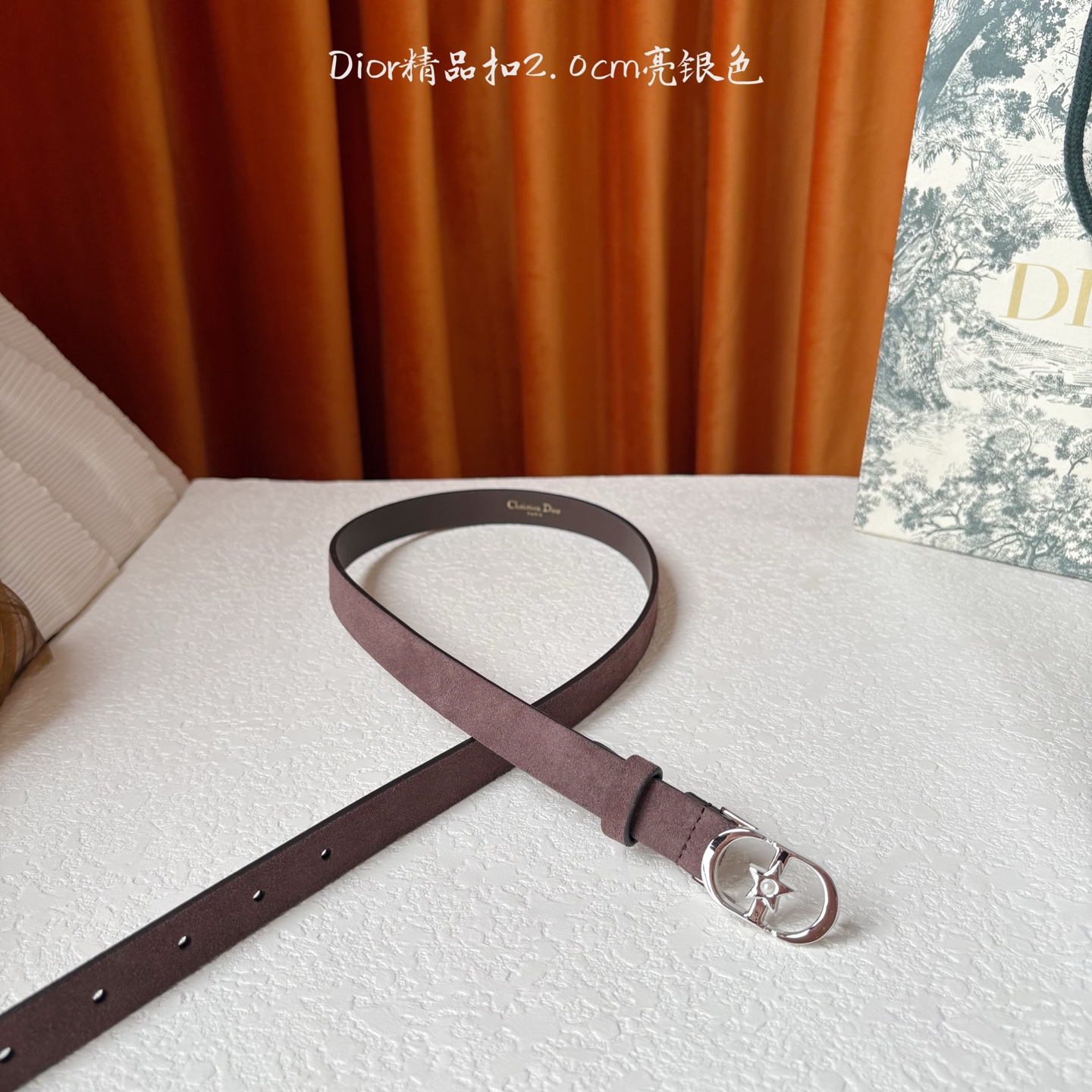 Dior的马鞍腰带已成为品牌的标志性款式，是每个衣橱的必备品。这款绒面小牛皮腰带重新演绎了这一经典款式，