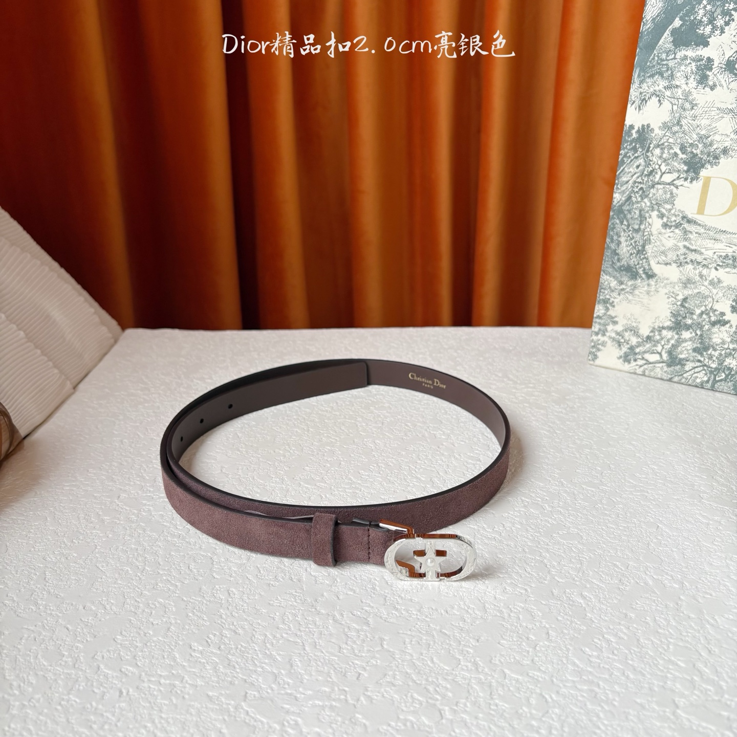 Dior的马鞍腰带已成为品牌的标志性款式，是每个衣橱的必备品。这款绒面小牛皮腰带重新演绎了这一经典款式，