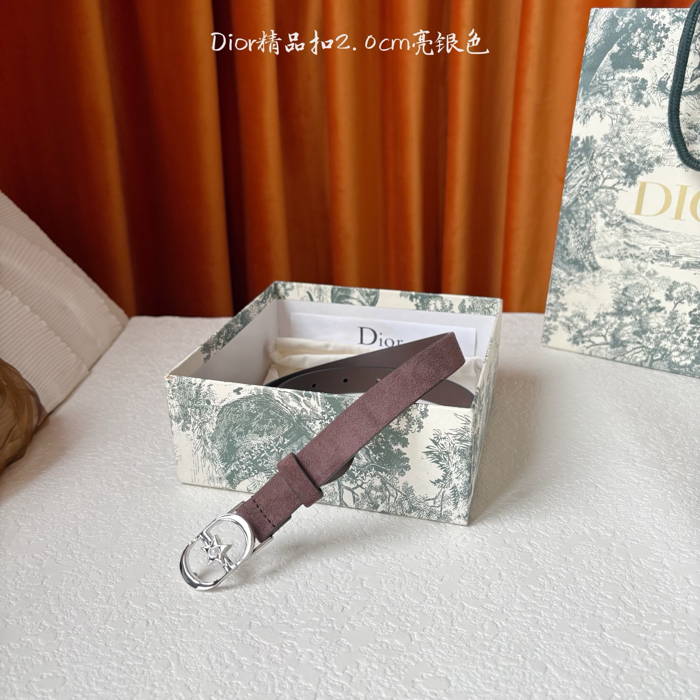 Dior的马鞍腰带已成为品牌的标志性款式，是每个衣橱的必备品。这款绒面小牛皮腰带重新演绎了这一经典款式，