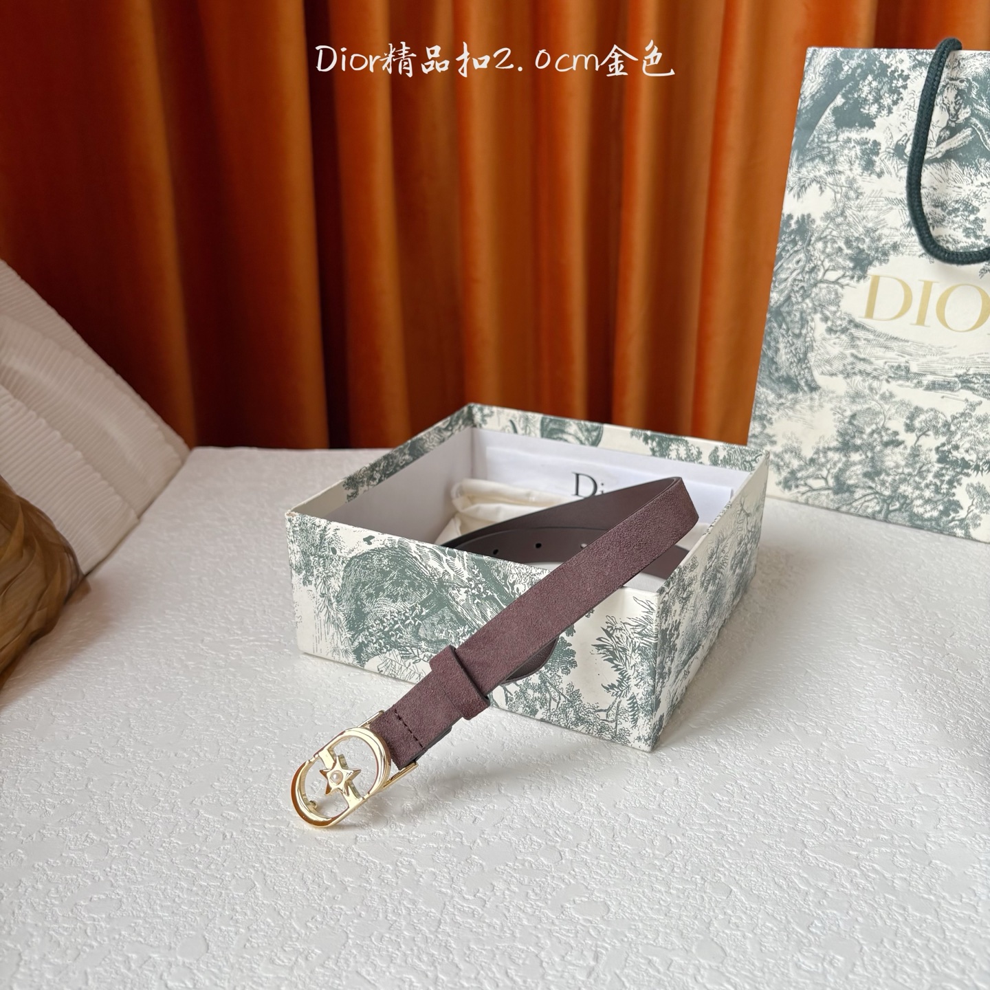 Dior的马鞍腰带已成为品牌的标志性款式，是每个衣橱的必备品。这款绒面小牛皮腰带重新演绎了这一经典款式，