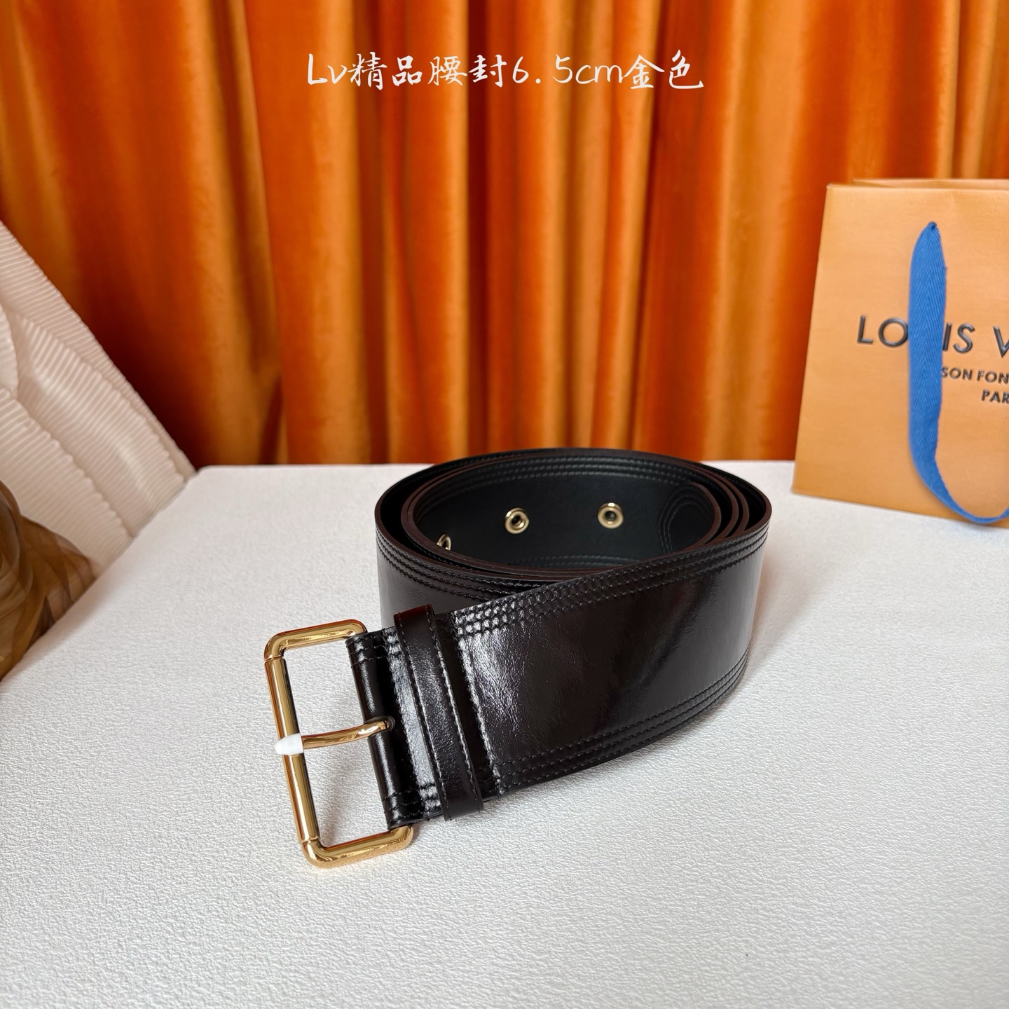 Lv Trench 65毫米腰带采用油蜡小牛皮制成，独一无二的腰带以众多孔眼和坚固的金色搭扣向著名外套的