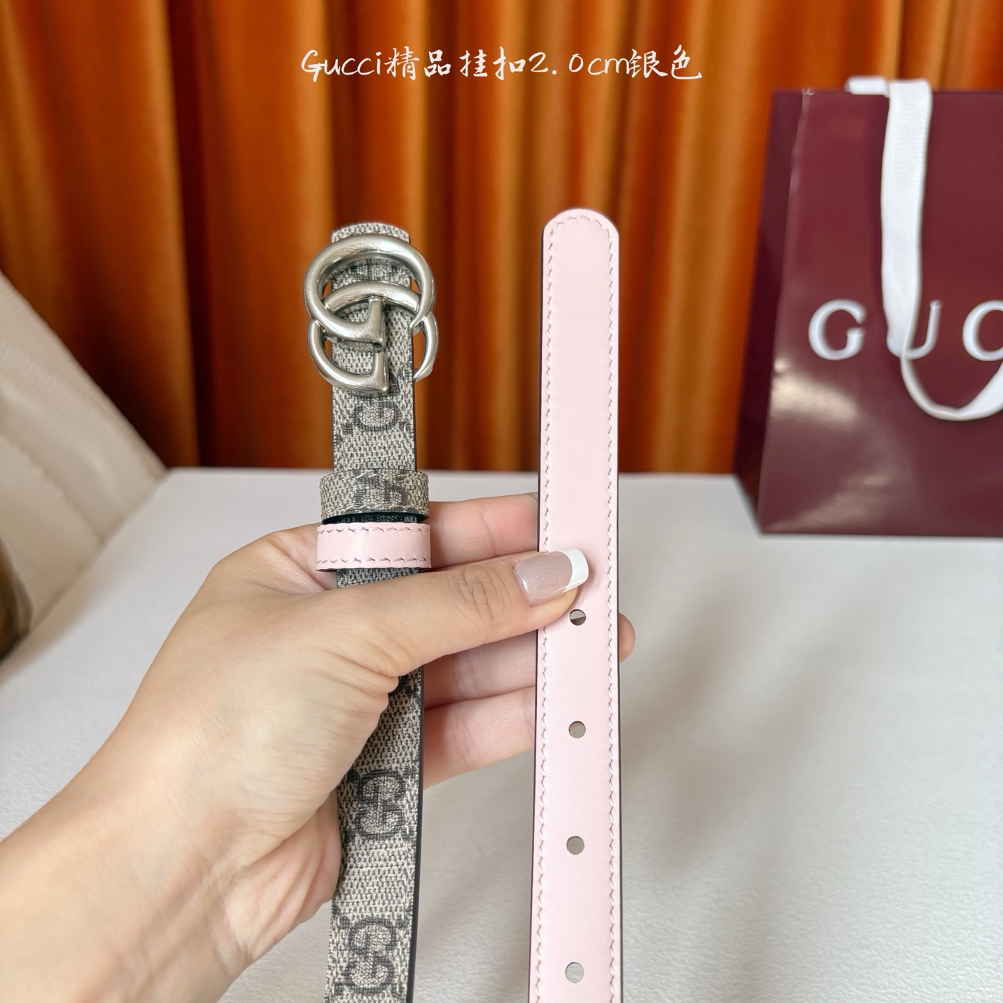 Gucci这款20MM腰带一面为柔软GG supreme帆布，另一面为粉红色牛皮革，搭配可拆卸互扣式双G