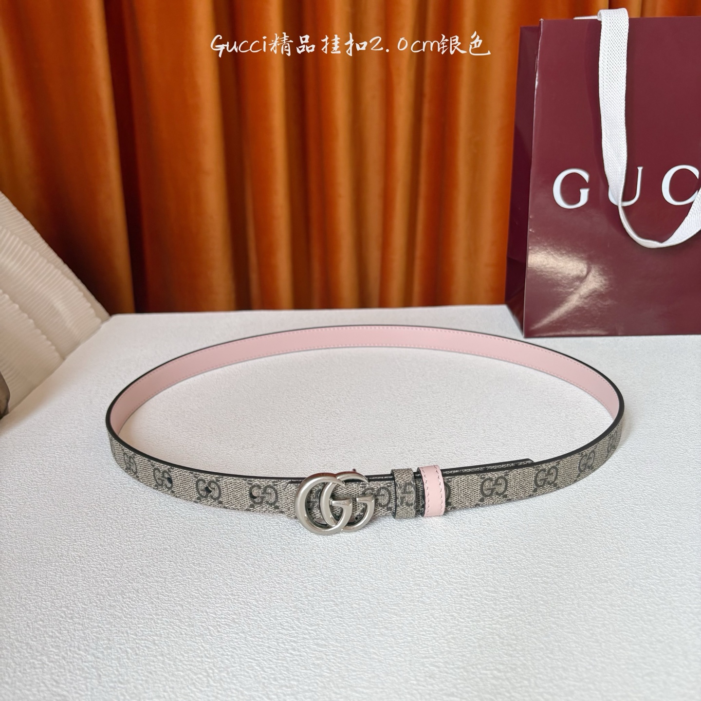 Gucci这款20MM腰带一面为柔软GG supreme帆布，另一面为粉红色牛皮革，搭配可拆卸互扣式双G