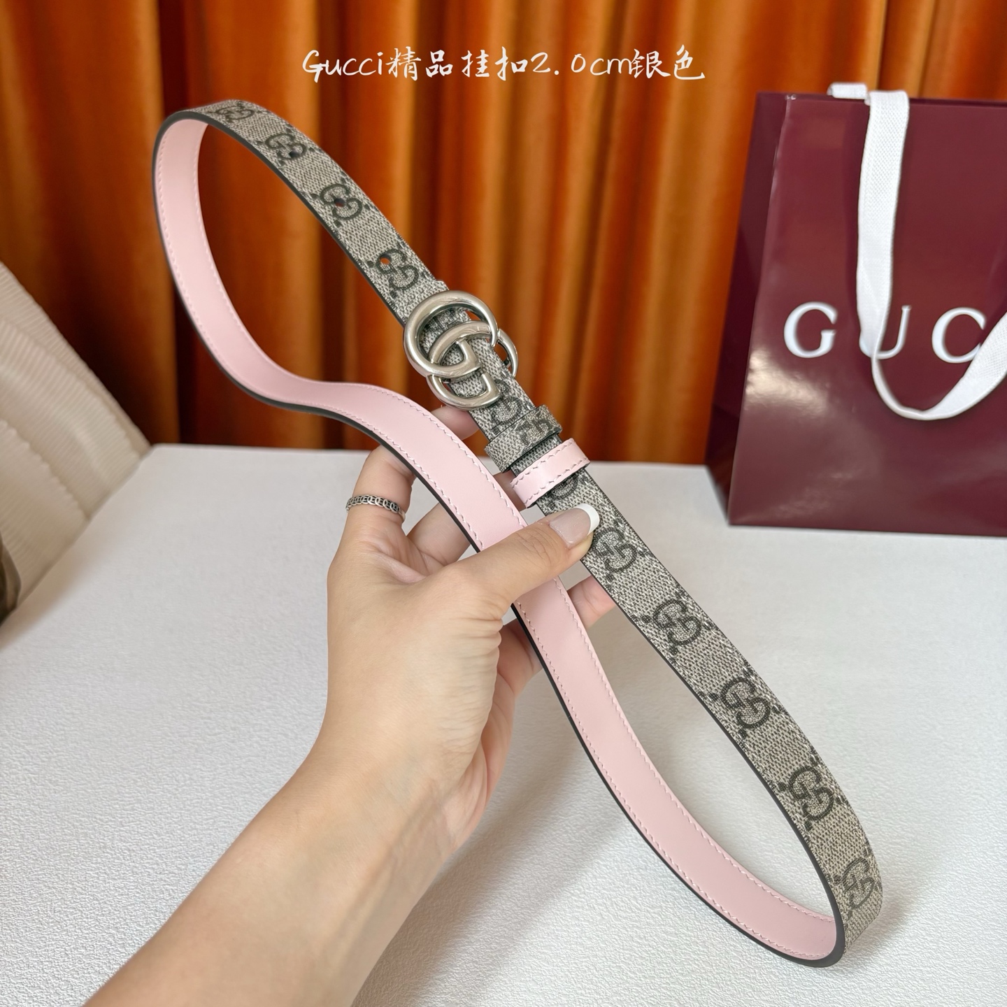 Gucci这款20MM腰带一面为柔软GG supreme帆布，另一面为粉红色牛皮革，搭配可拆卸互扣式双G