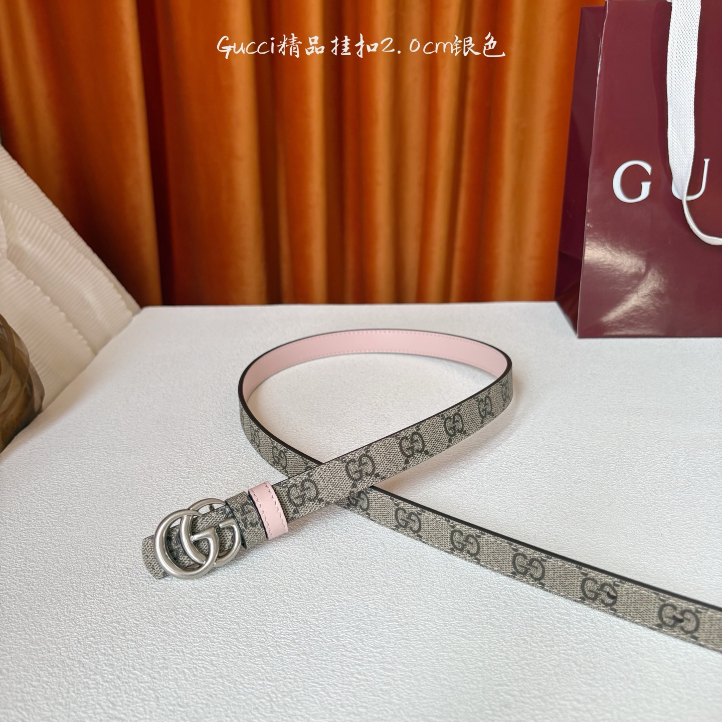 Gucci这款20MM腰带一面为柔软GG supreme帆布，另一面为粉红色牛皮革，搭配可拆卸互扣式双G