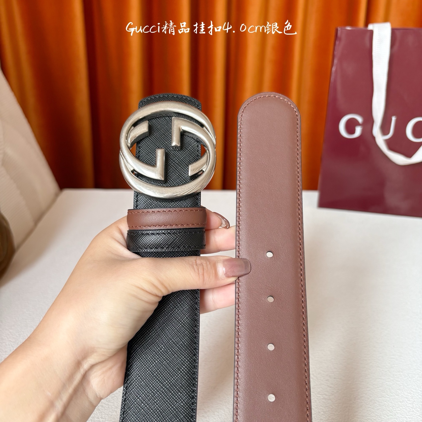 Gucci这款腰带一面为黑色粒面牛皮革，另一面为深棕色牛皮革，搭配可拆卸互扣式双G造型腰带扣，宽4.0c