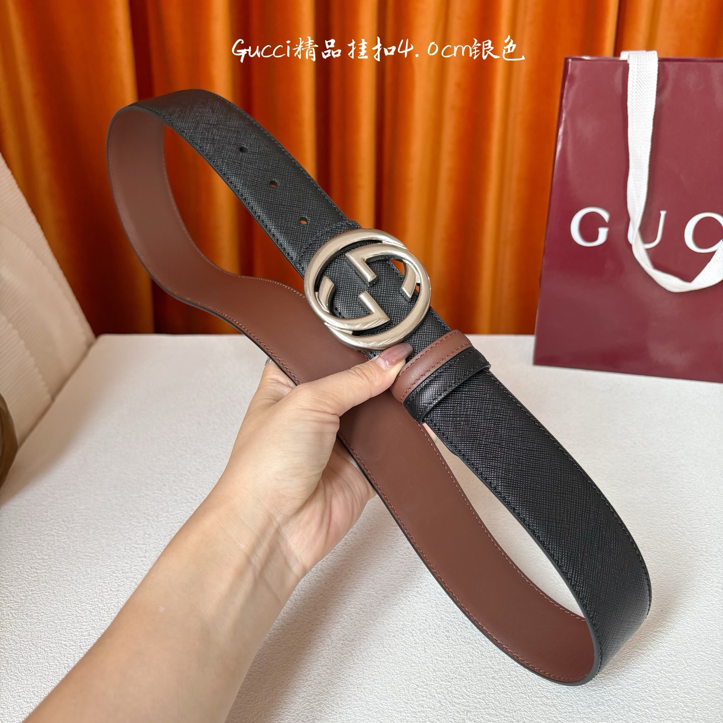 Gucci这款腰带一面为黑色粒面牛皮革，另一面为深棕色牛皮革，搭配可拆卸互扣式双G造型腰带扣，宽4.0c