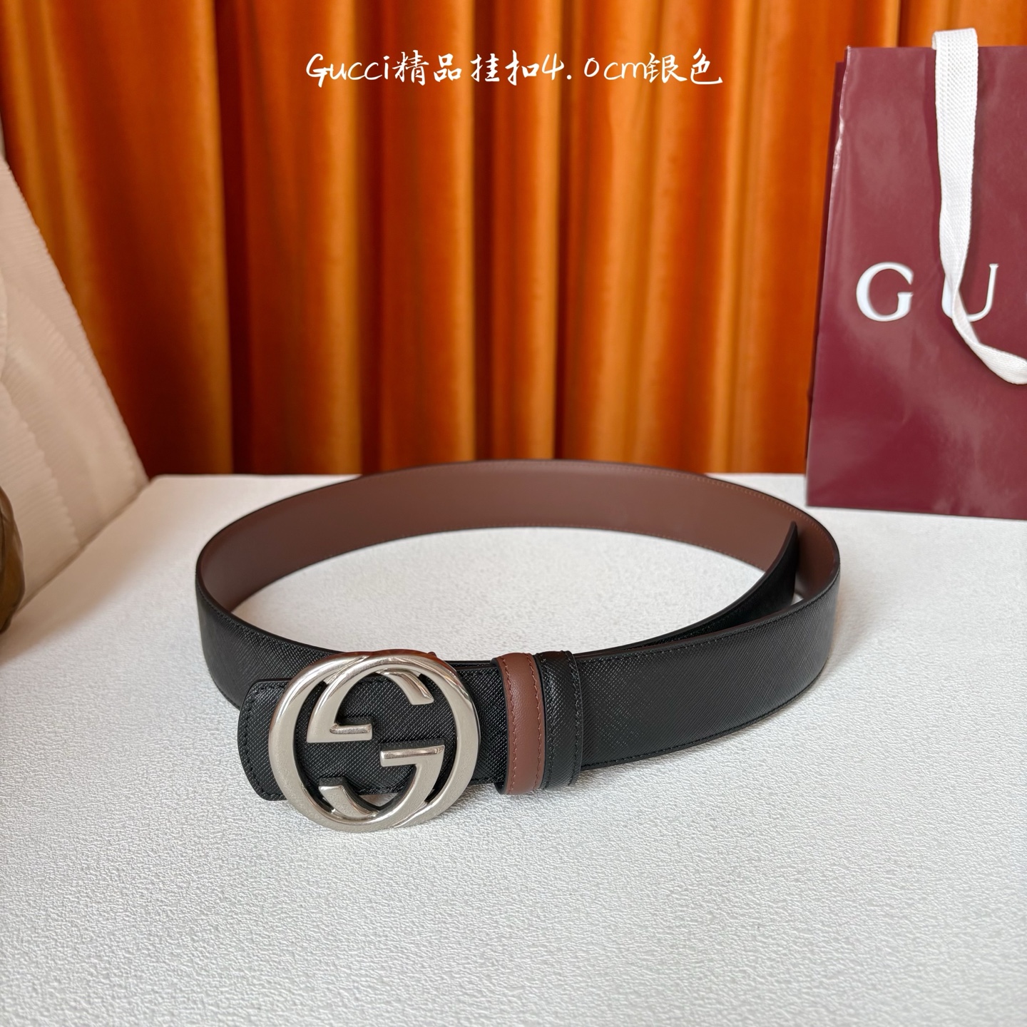 Gucci这款腰带一面为黑色粒面牛皮革，另一面为深棕色牛皮革，搭配可拆卸互扣式双G造型腰带扣，宽4.0c