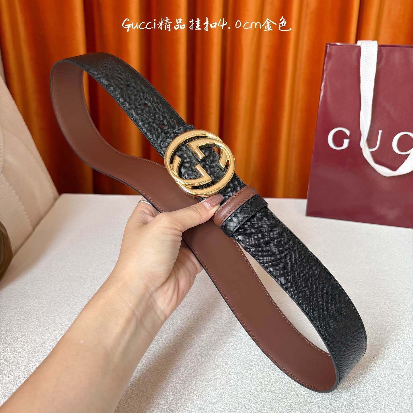 Gucci这款腰带一面为黑色粒面牛皮革，另一面为深棕色牛皮革，搭配可拆卸互扣式双G造型腰带扣，宽4.0c