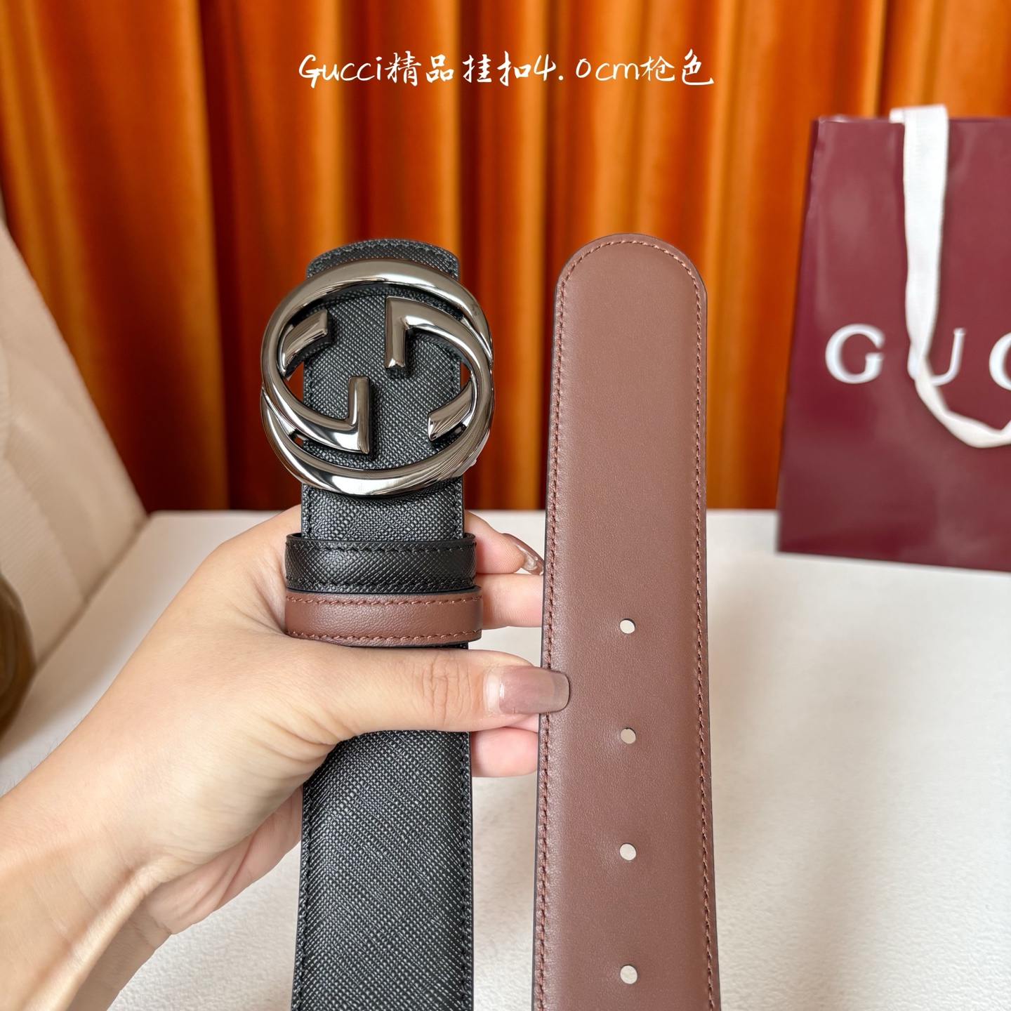 Gucci这款腰带一面为黑色粒面牛皮革，另一面为深棕色牛皮革，搭配可拆卸互扣式双G造型腰带扣，宽4.0c