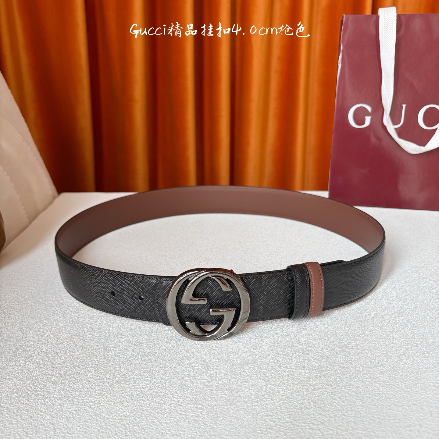 Gucci这款腰带一面为黑色粒面牛皮革，另一面为深棕色牛皮革，搭配可拆卸互扣式双G造型腰带扣，宽4.0c