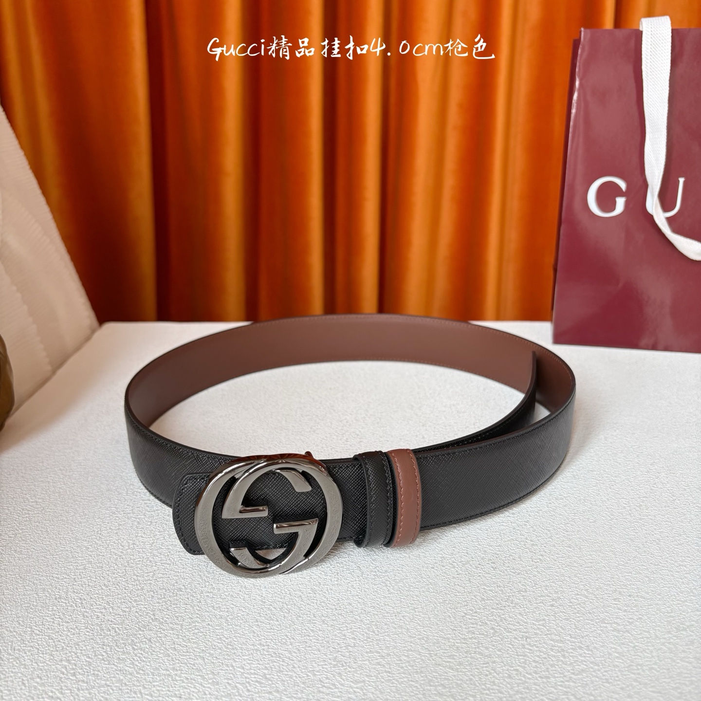 Gucci这款腰带一面为黑色粒面牛皮革，另一面为深棕色牛皮革，搭配可拆卸互扣式双G造型腰带扣，宽4.0c
