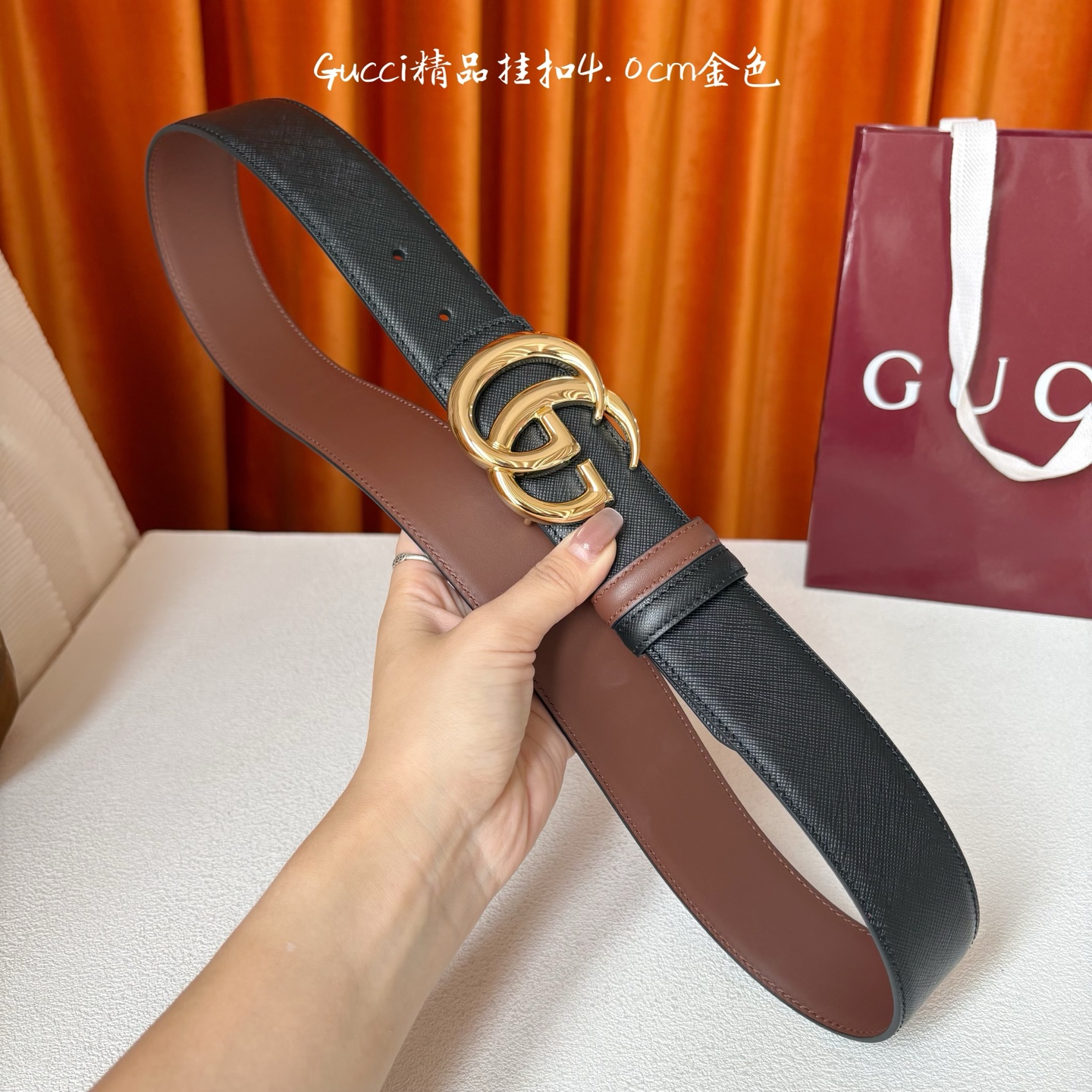 Gucci这款腰带一面为黑色粒面牛皮革，另一面为深棕色牛皮革，搭配可拆卸互扣式双G造型腰带扣，宽4.0c