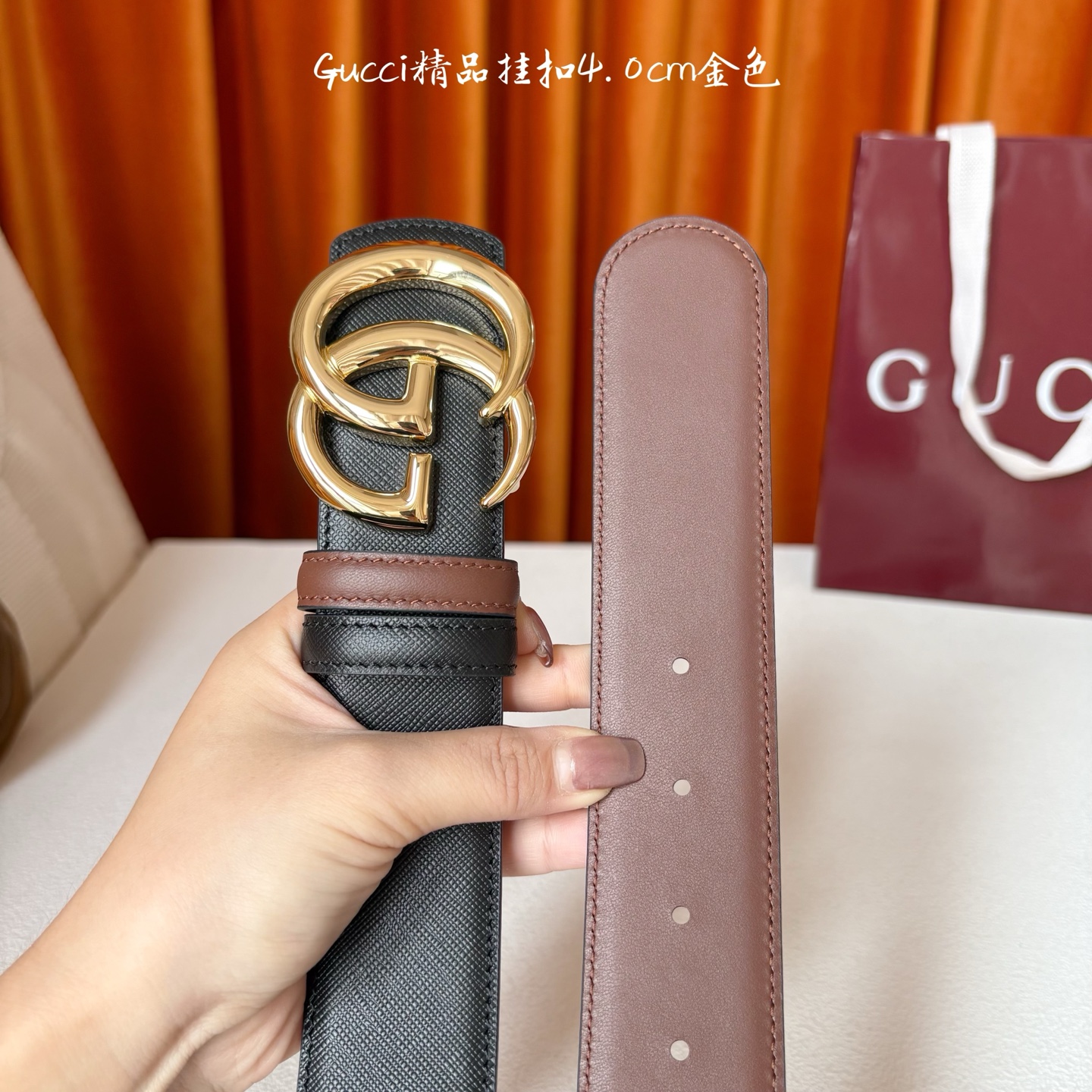 Gucci这款腰带一面为黑色粒面牛皮革，另一面为深棕色牛皮革，搭配可拆卸互扣式双G造型腰带扣，宽4.0c