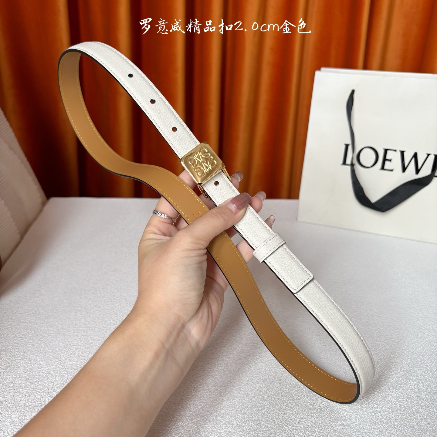 Loewe 鹅卵石纹牛皮腰带。方形带罗意威经典图案扣 宽2.0cm，五孔调节。白色/金扣