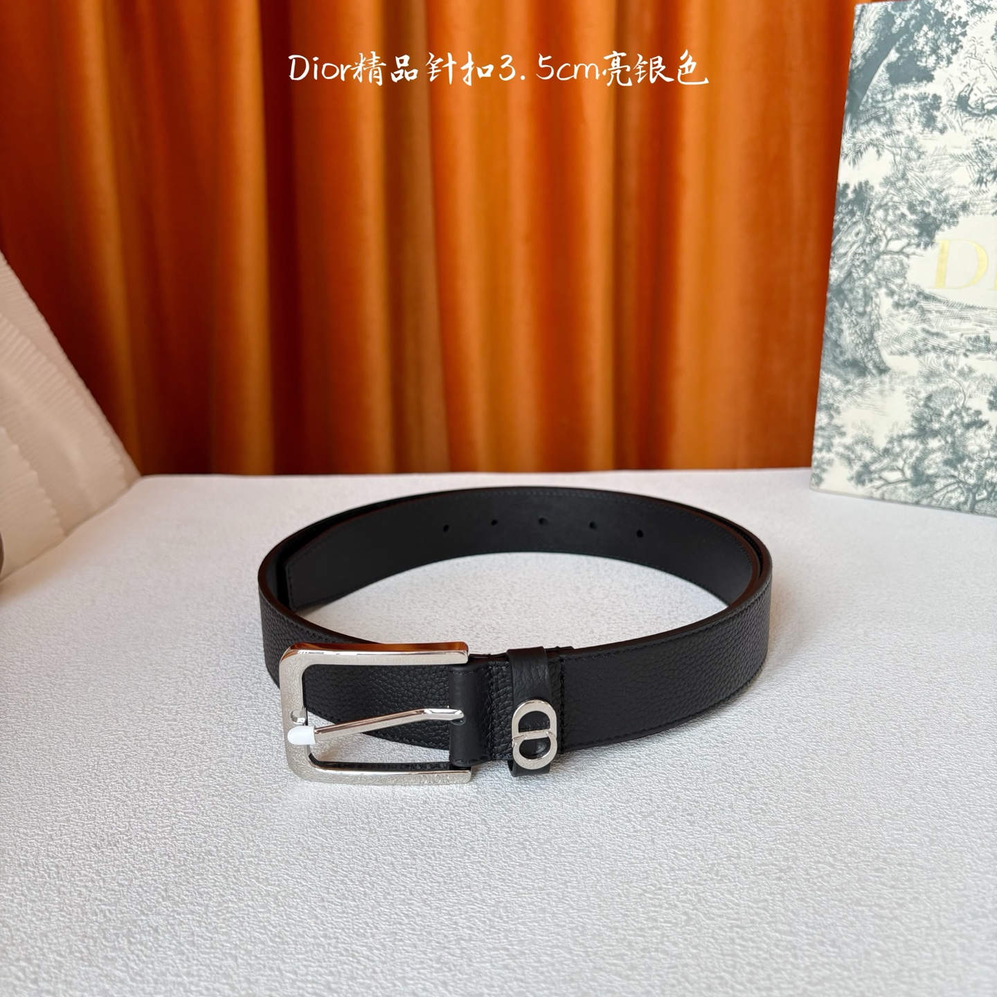 Dior这款腰带采用黑色粒面牛皮革精心制作，饰以镌刻有 Dior 的针扣和金属 CD Icon 标志腰带